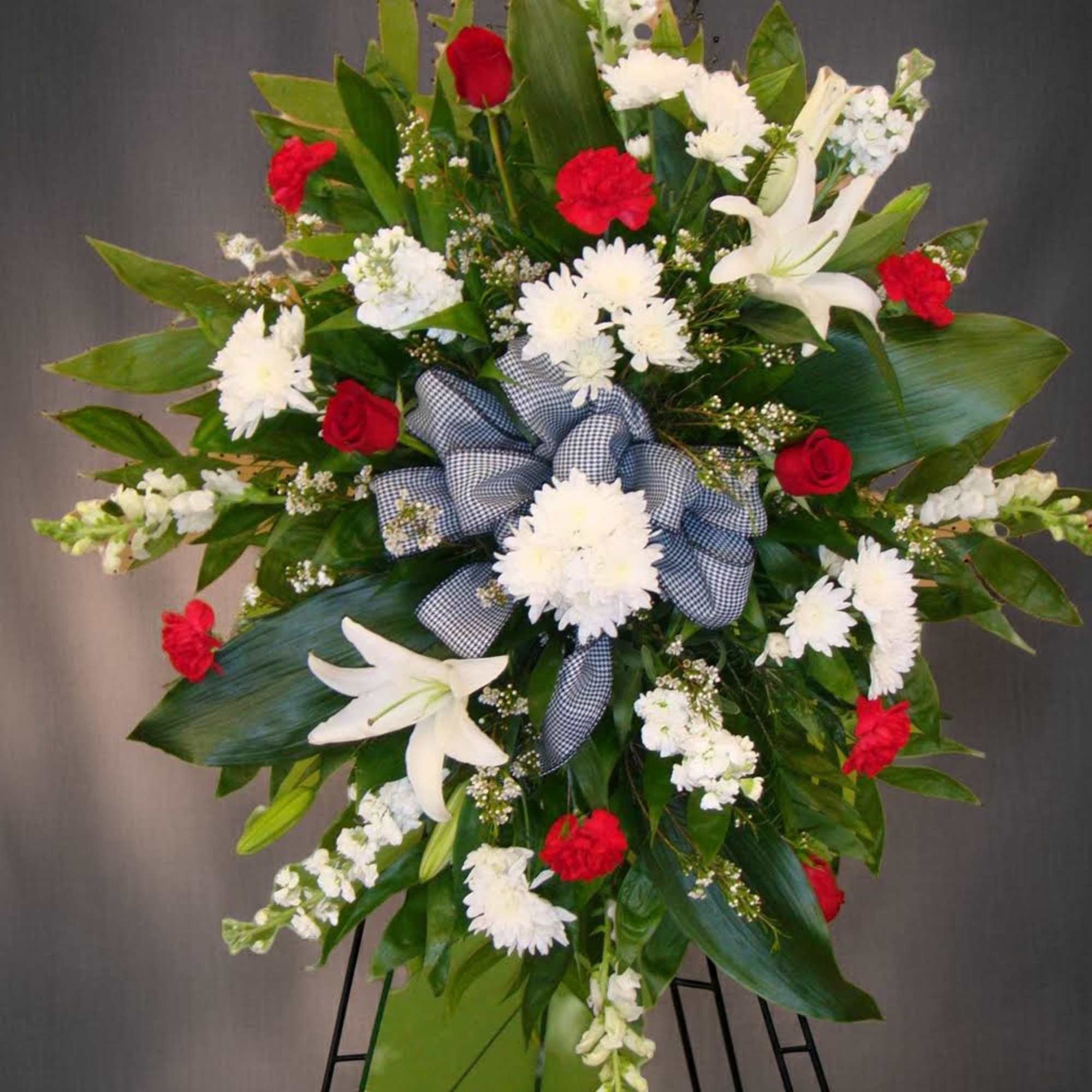 Standing floral spray with white lilies, red roses, and white chrysanthemums