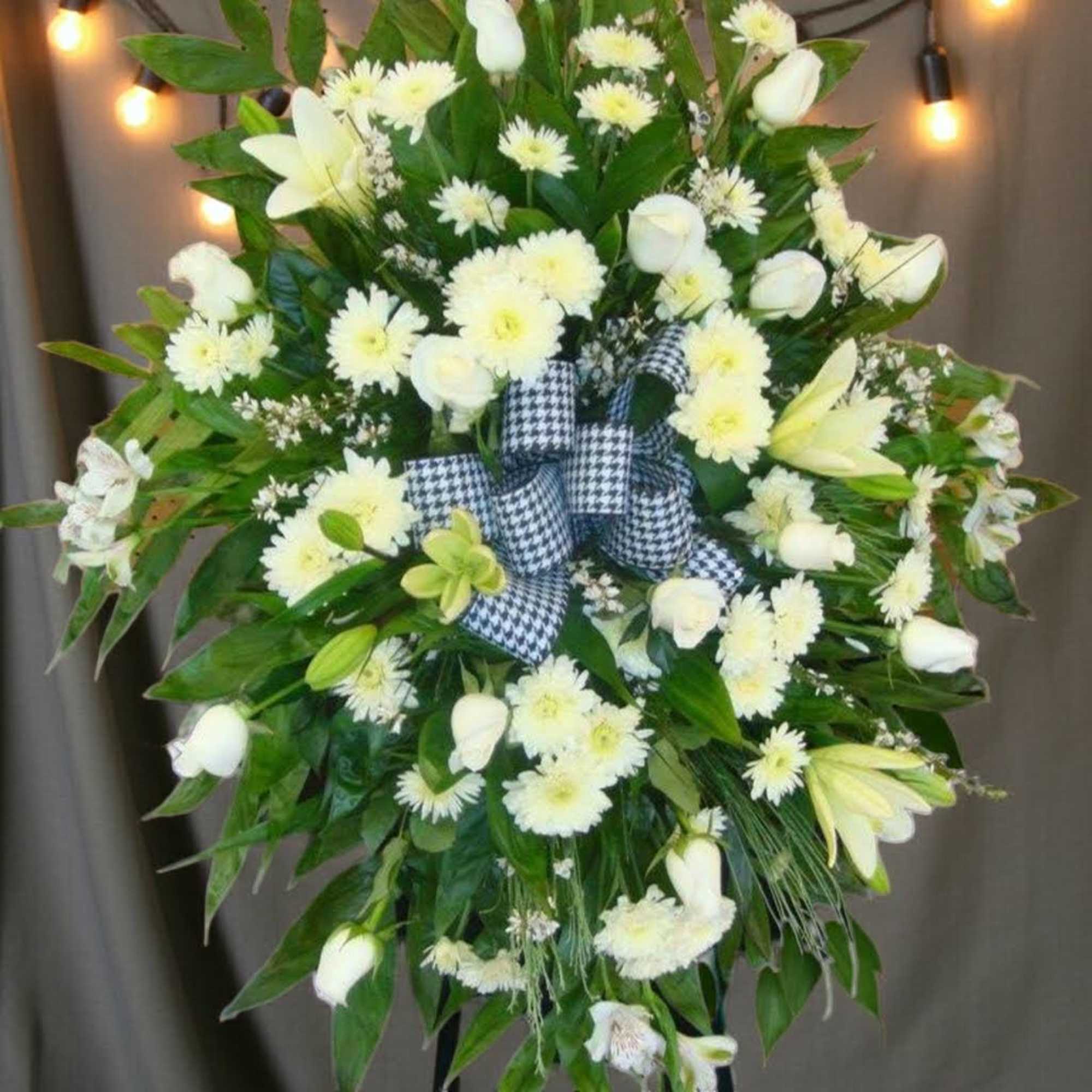 White floral standing spray with a black-and-white ribbon bow