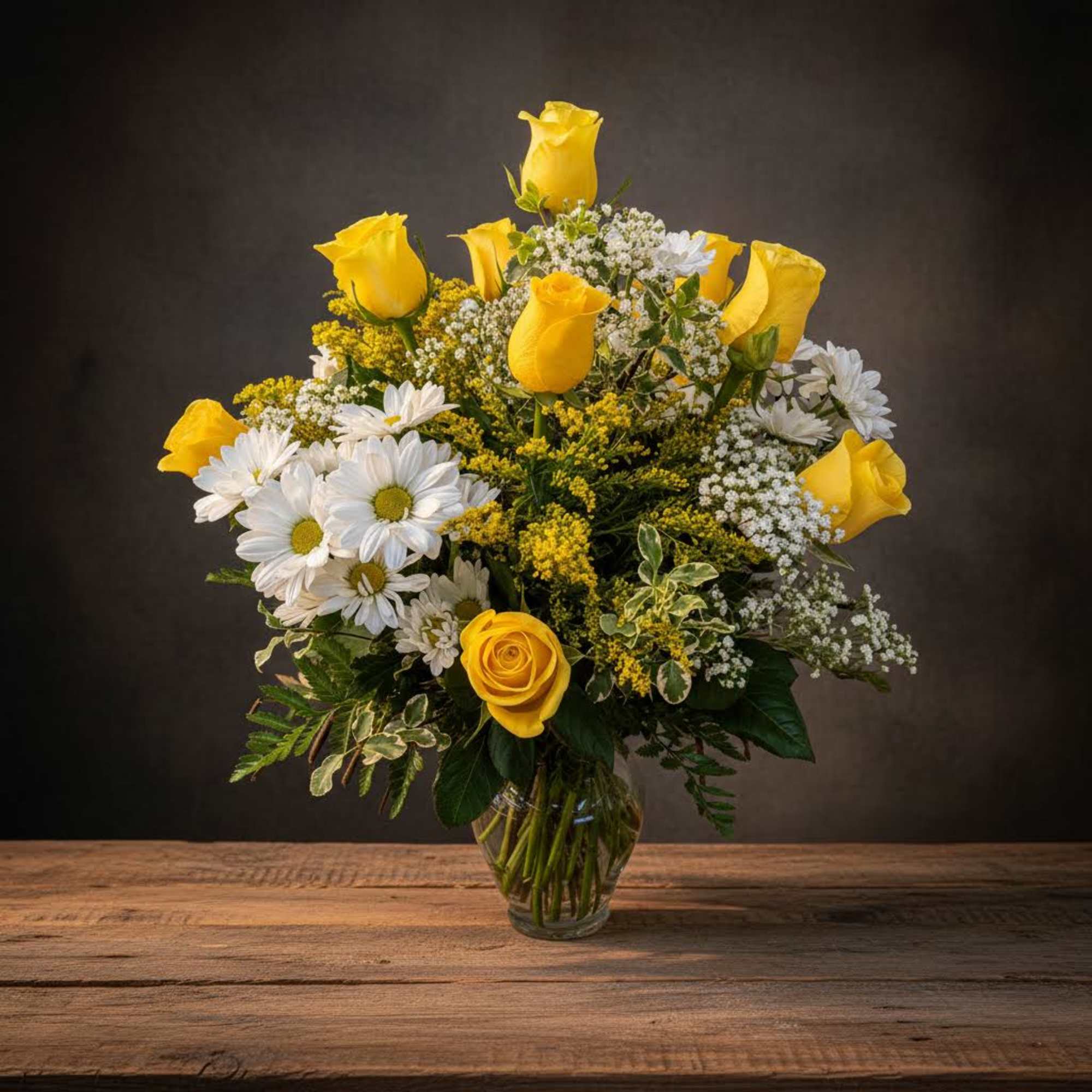 Yellow roses and white daisies in a glass vase