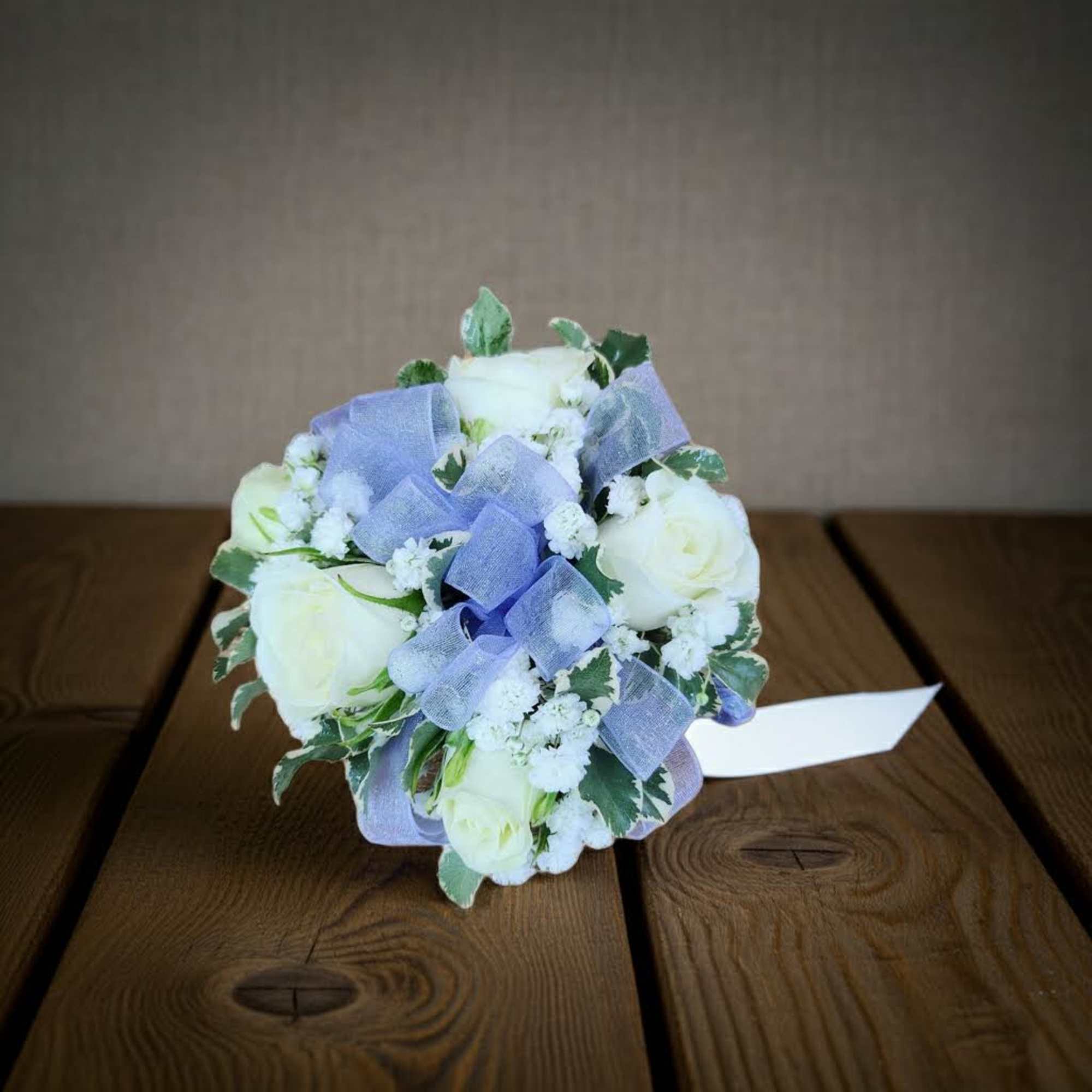 Small bouquet of white roses with lavender ribbon and white filler flowers