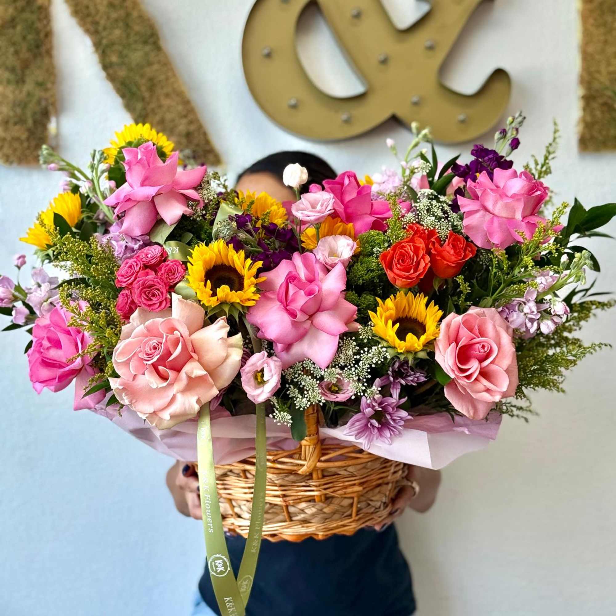 Basket arrangement of pink roses and sunflowers