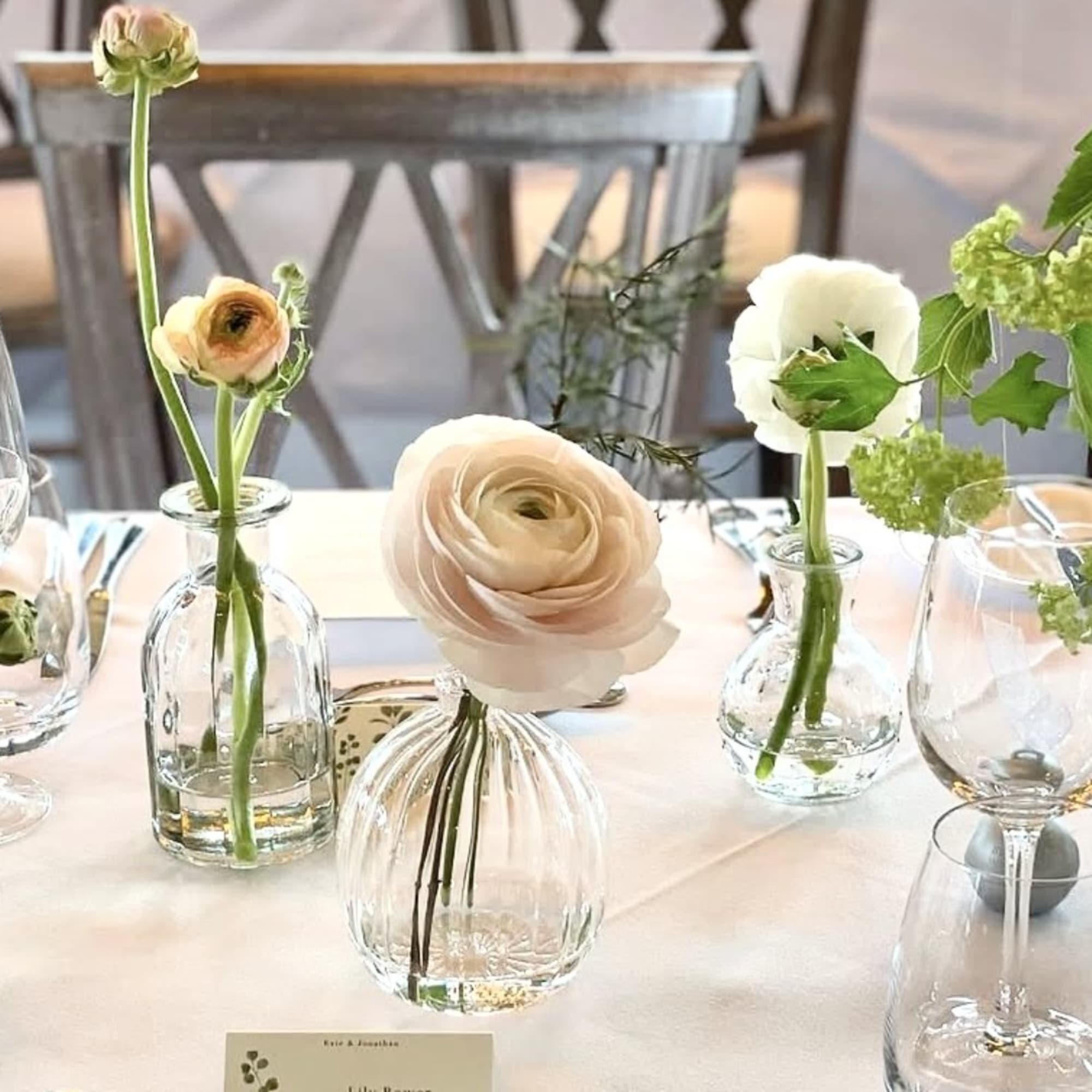Small floral arrangements in clear glass vases on a table