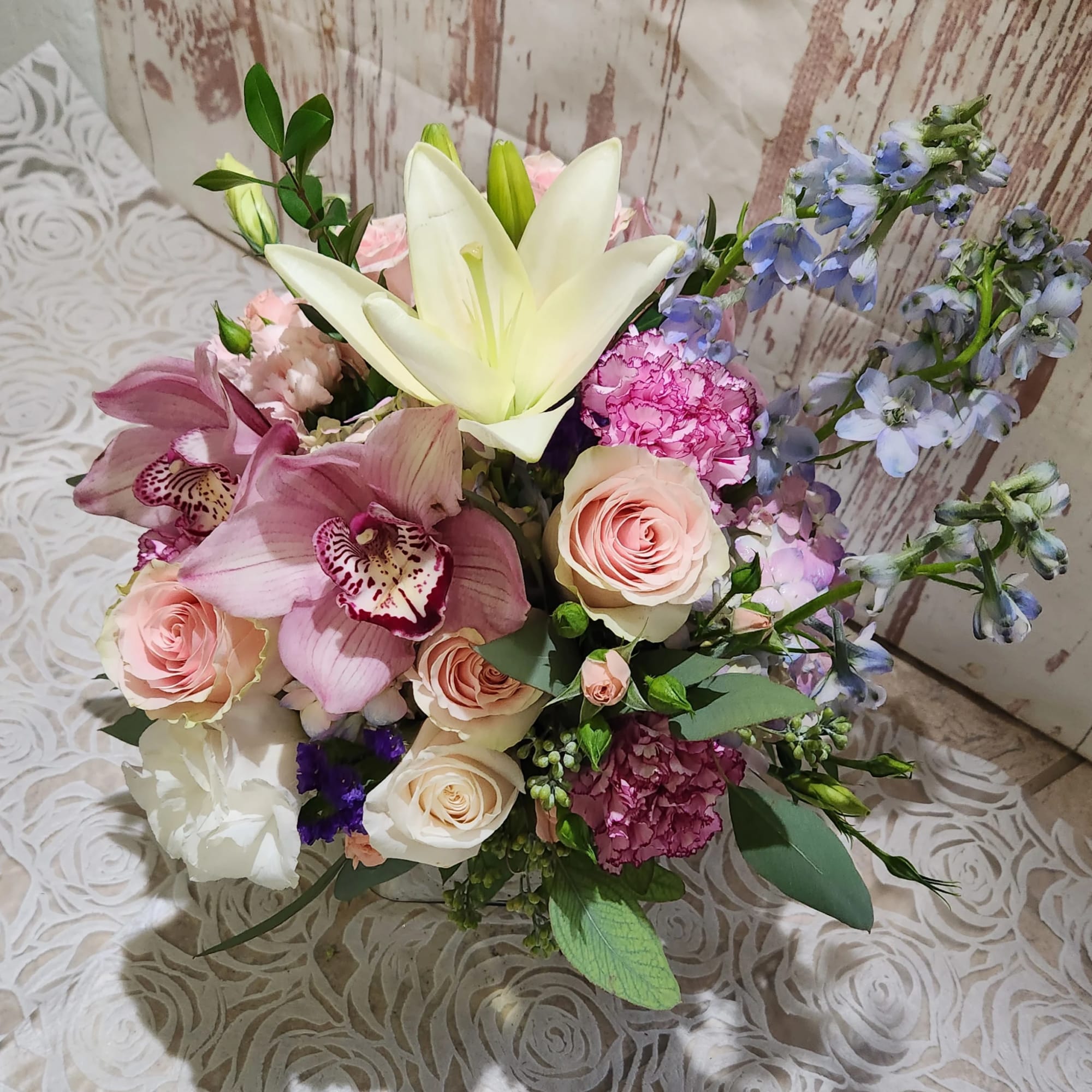 Bouquet of lilies, roses, orchids, and blue flowers