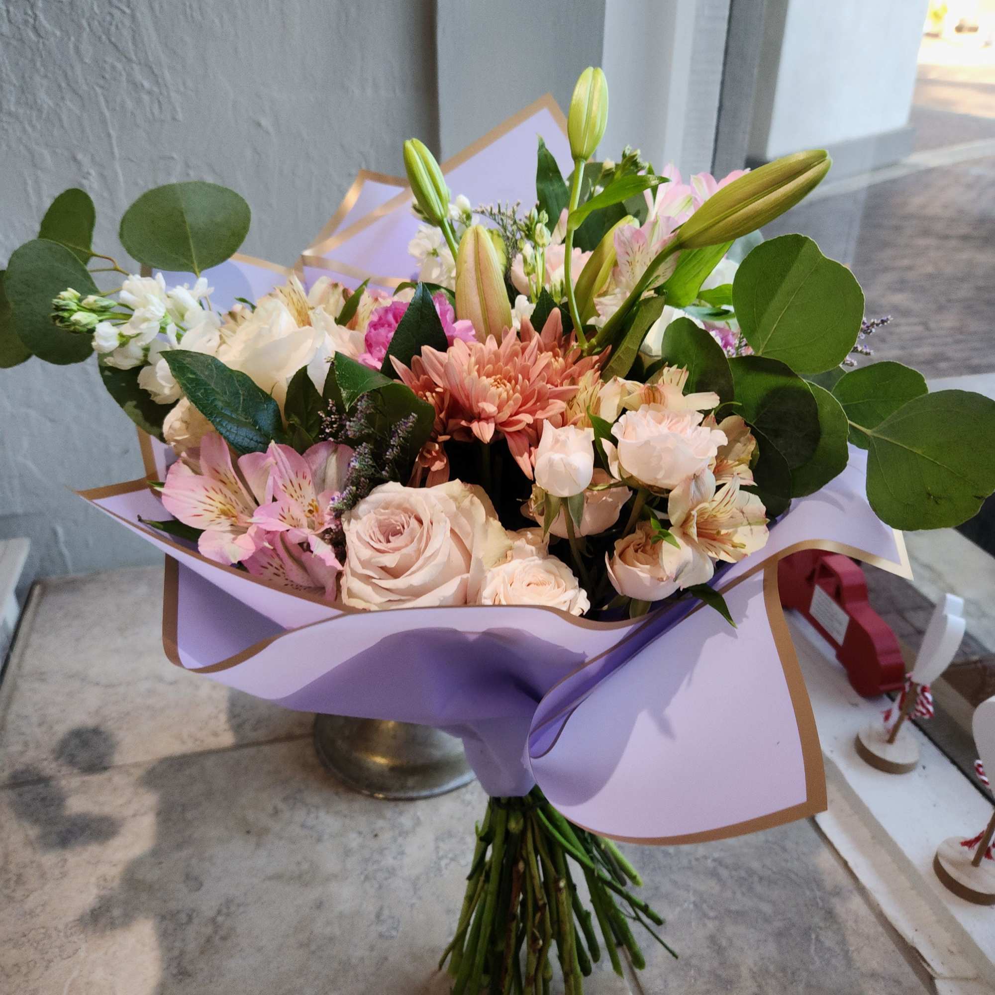 Bouquet of pink and white flowers wrapped in lavender paper