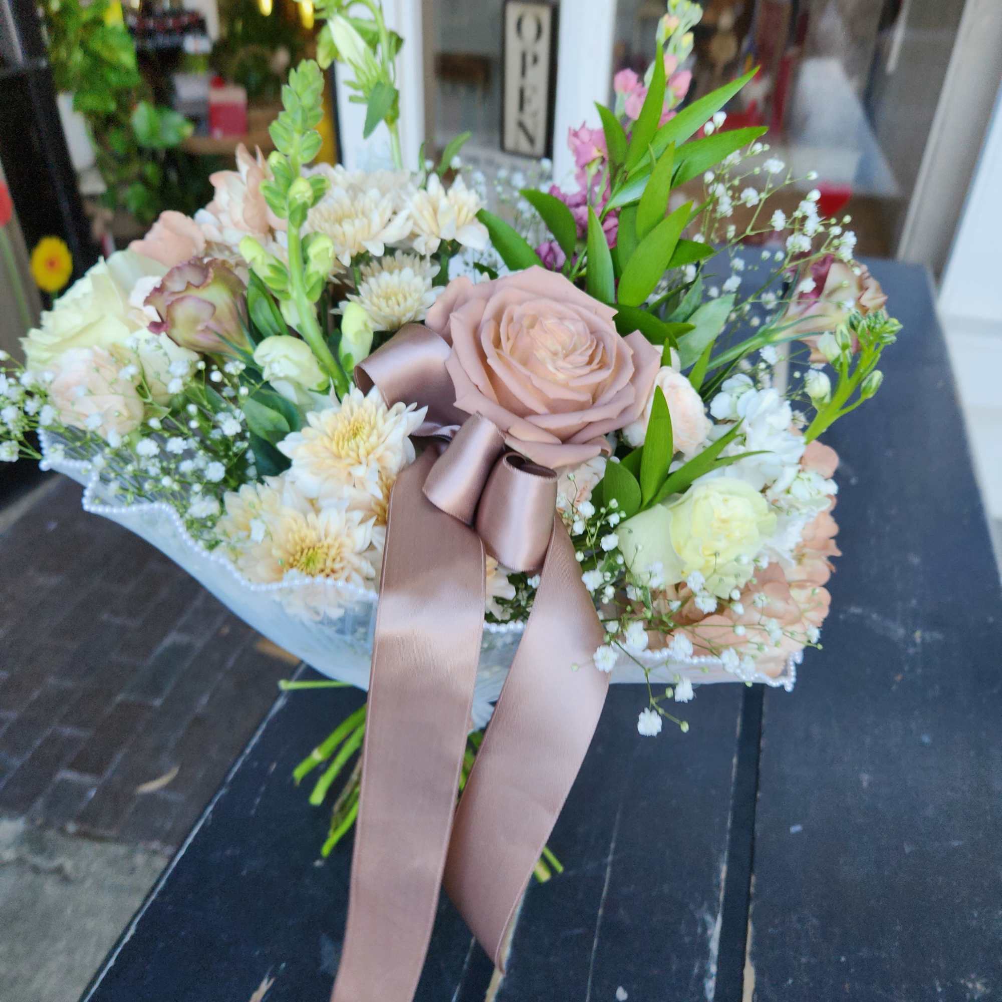 Blush rose bouquet with white blooms and a satin ribbon