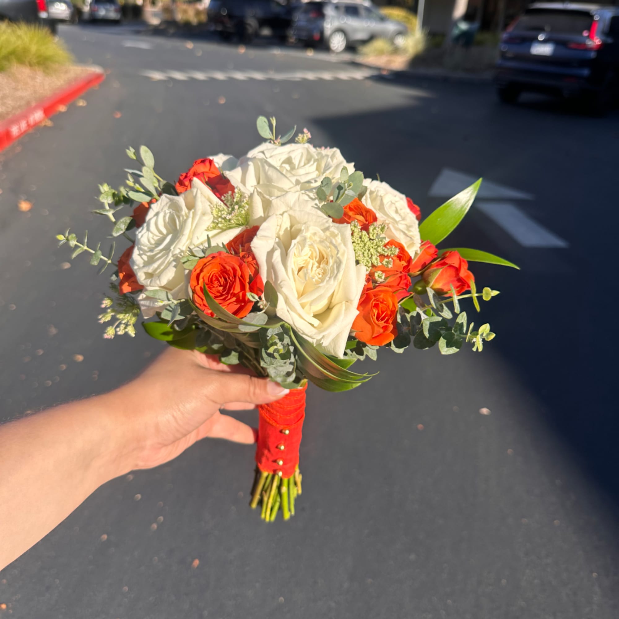 Handheld bouquet of white and orange roses with greenery, photo 3 of 4