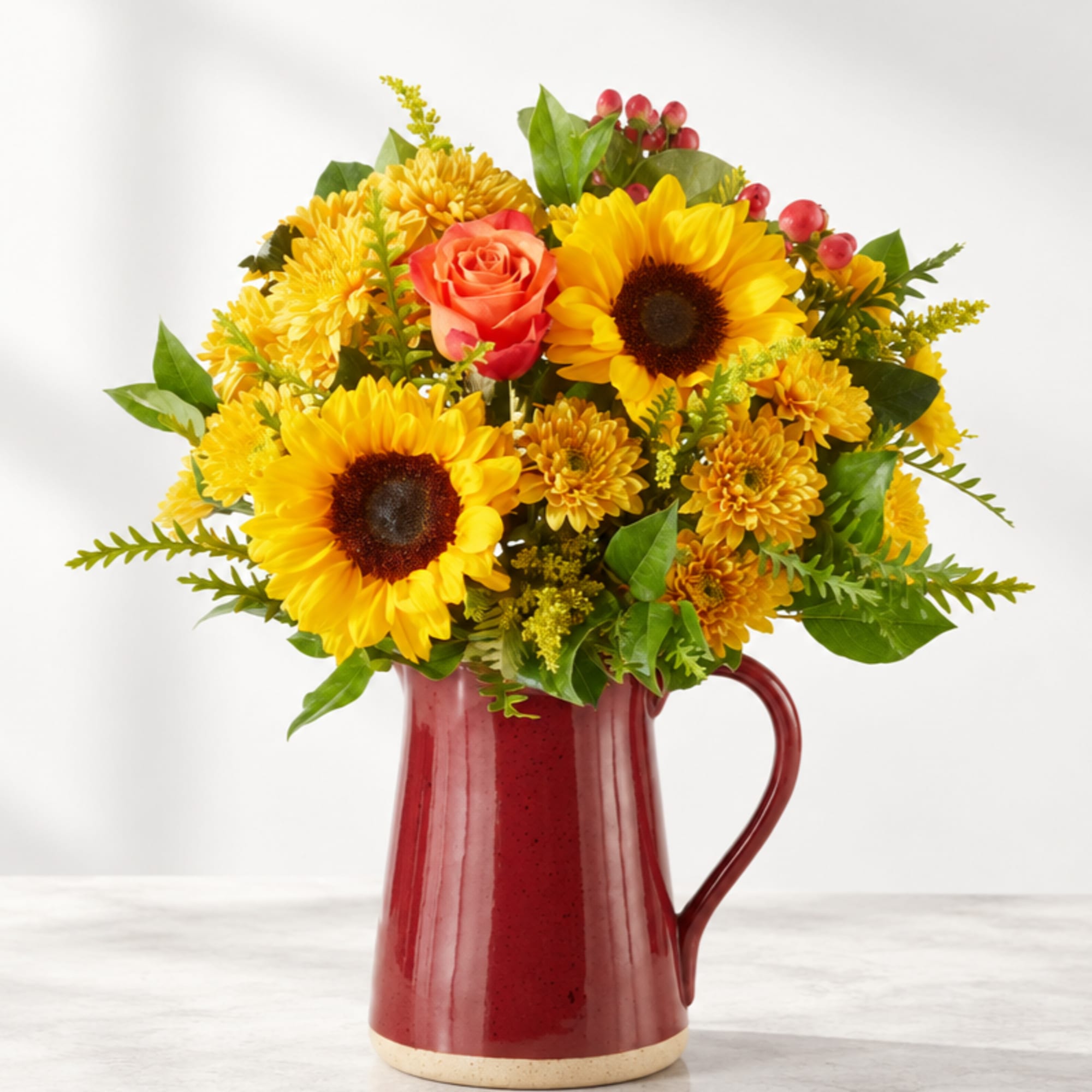 Sunflower and rose bouquet in a red ceramic pitcher