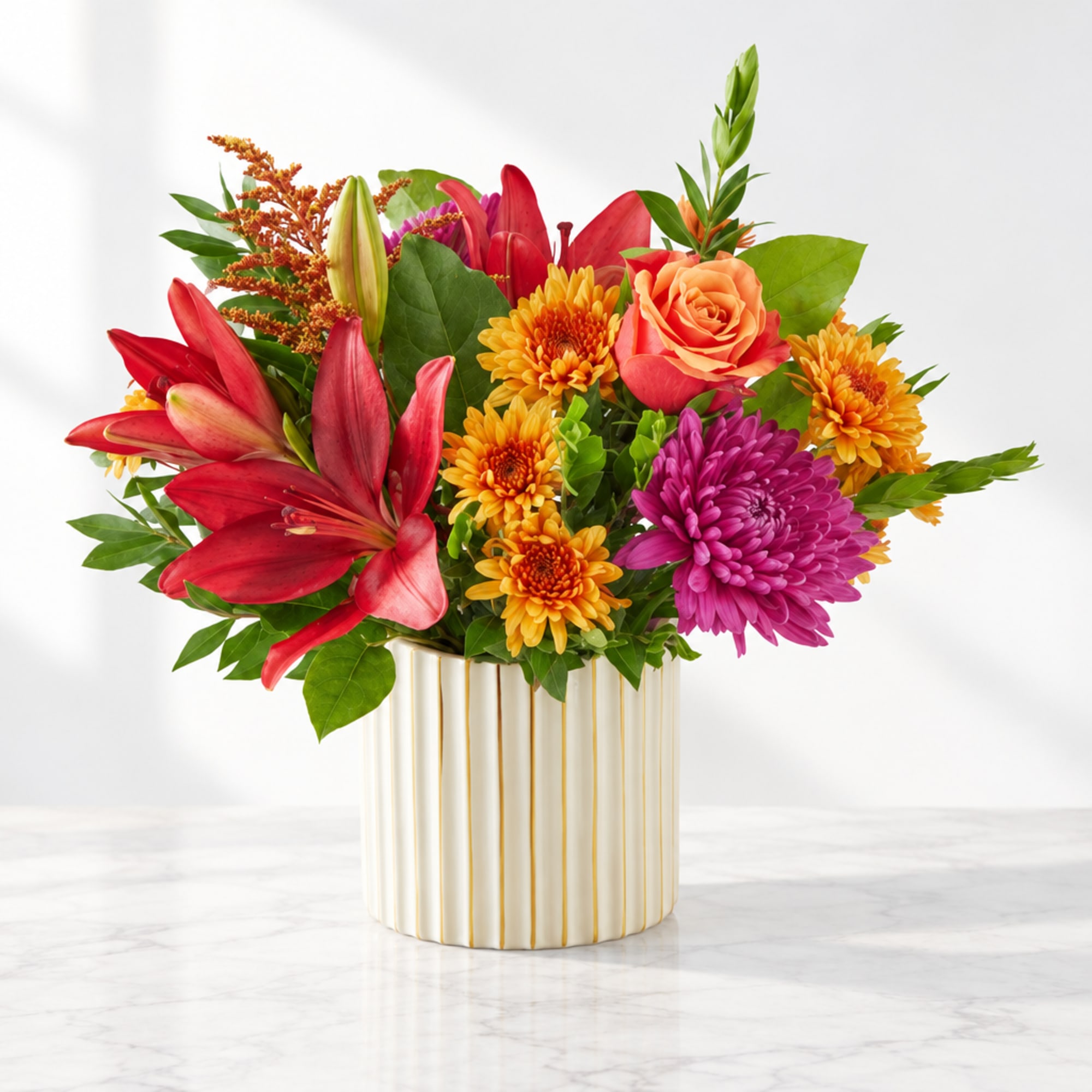 Colorful bouquet of lilies, roses, and chrysanthemums in a striped vase