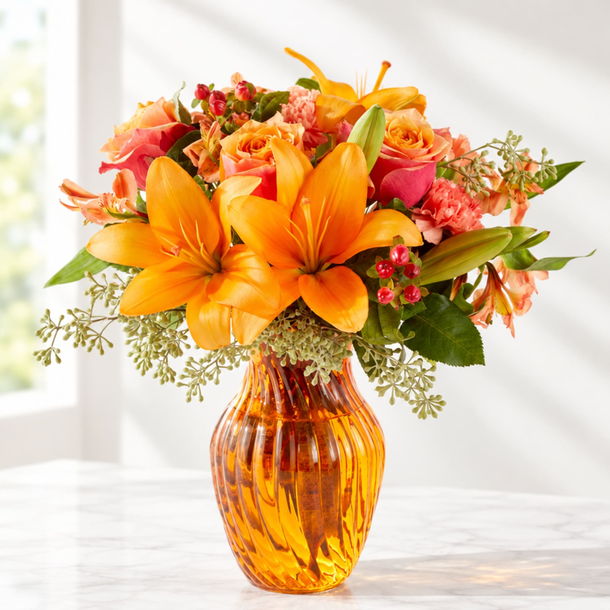 Orange lilies and pink roses in an amber glass vase