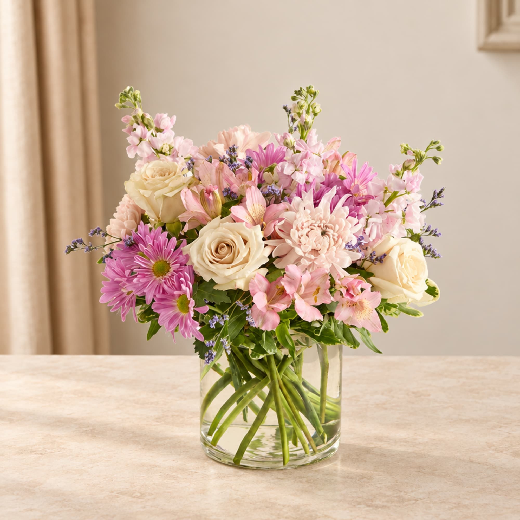 Pink and cream mixed bouquet in a clear glass vase