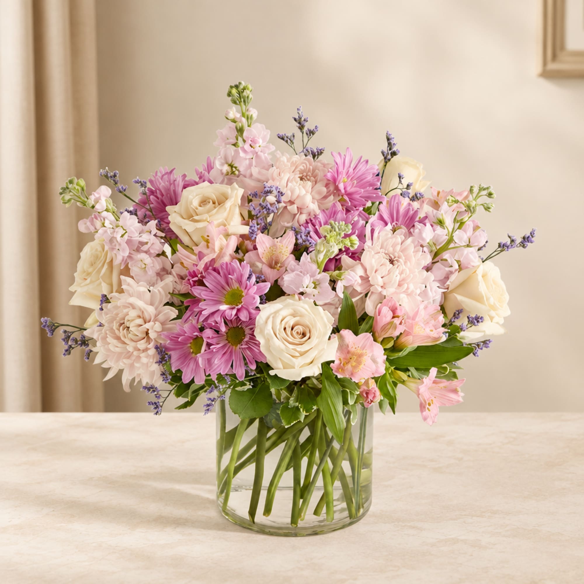 Pink and cream bouquet in a clear glass vase