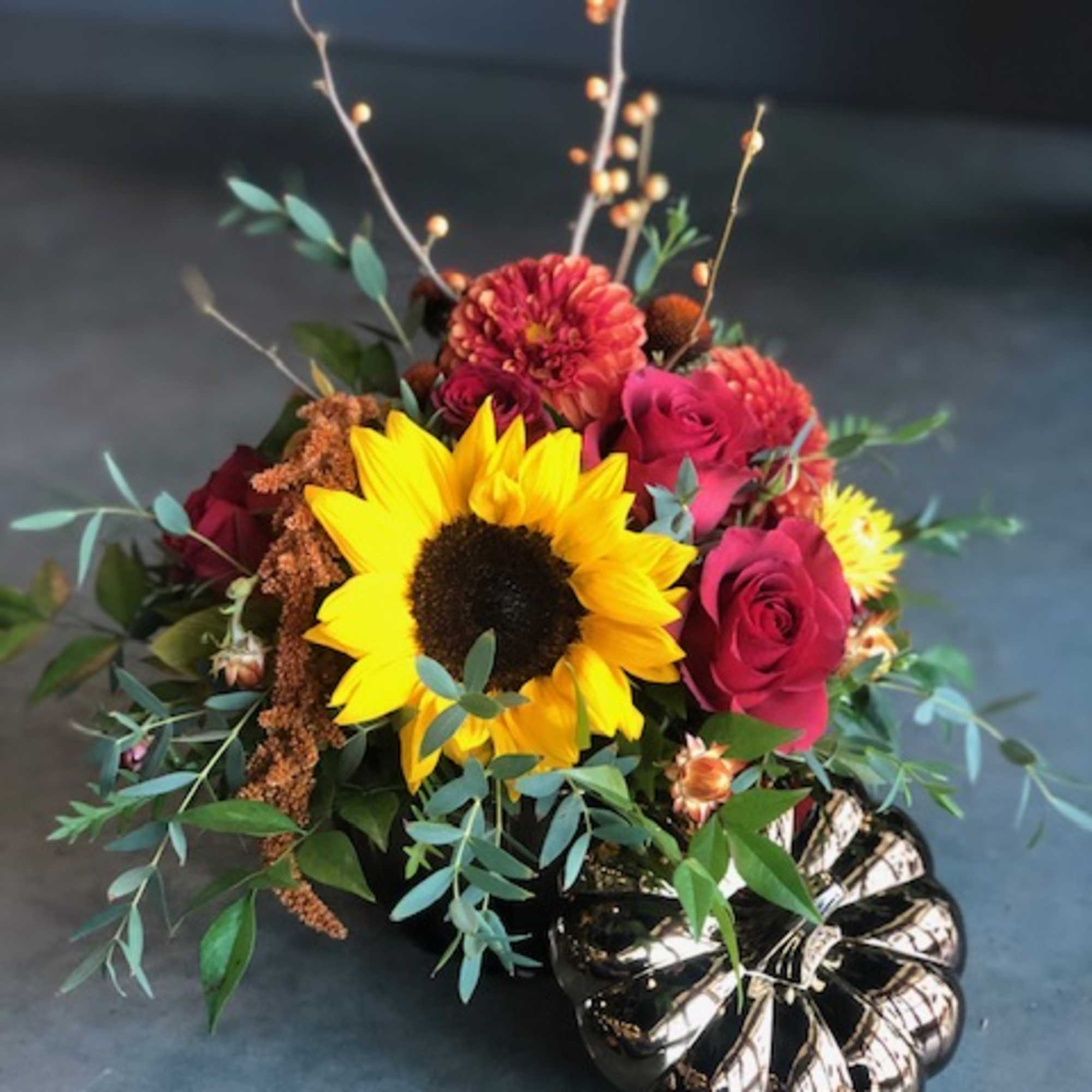 Sunflower and red rose arrangement in a metallic pumpkin container