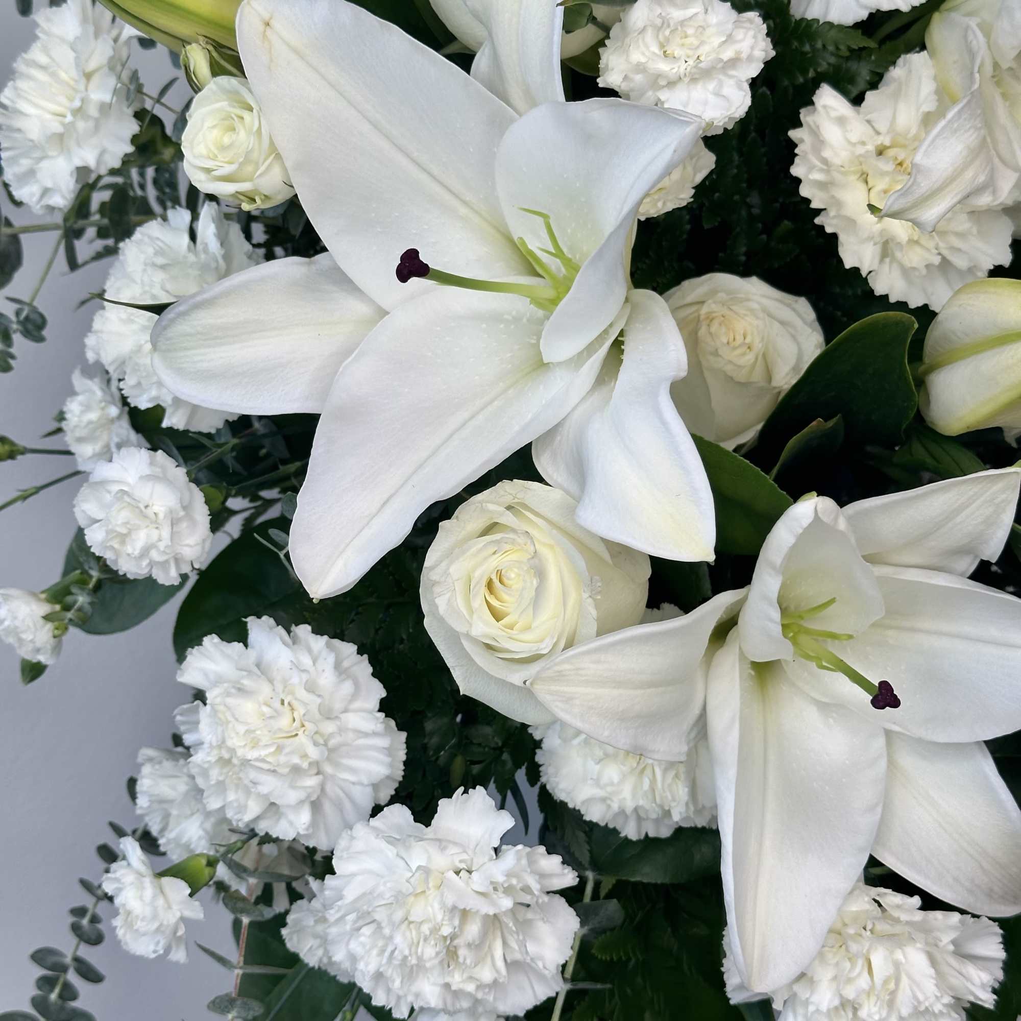 White lilies and carnations with white roses in a bouquet