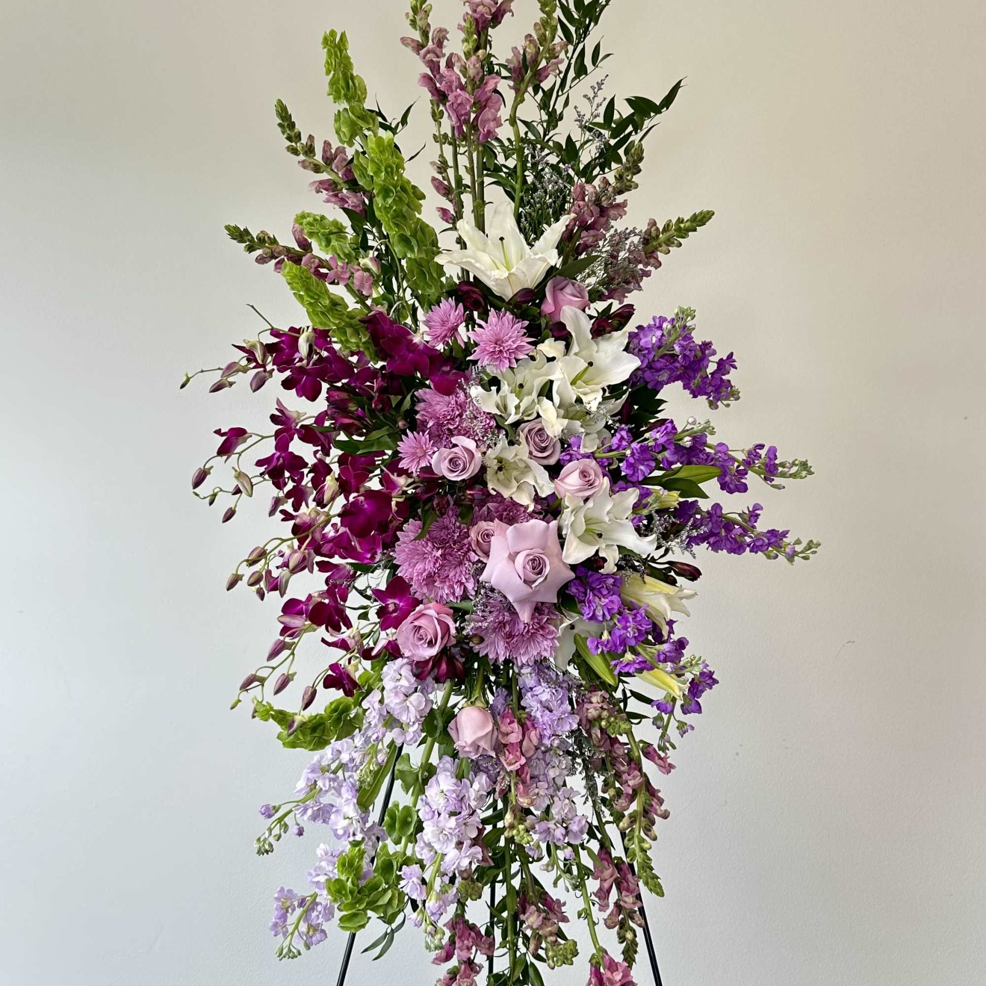Tall standing floral spray with purple, pink, and white blooms