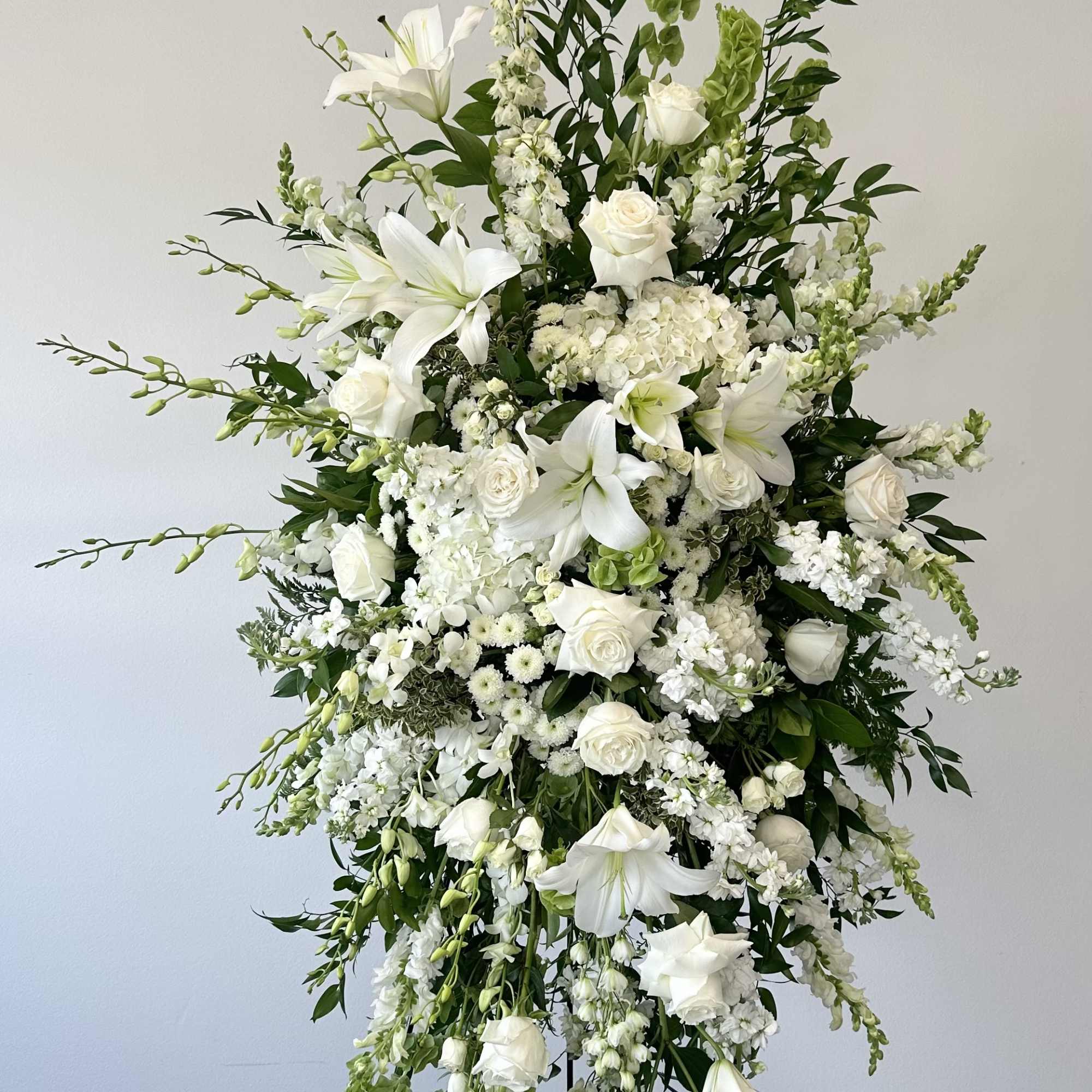 Tall white floral spray with lilies and roses on a stand