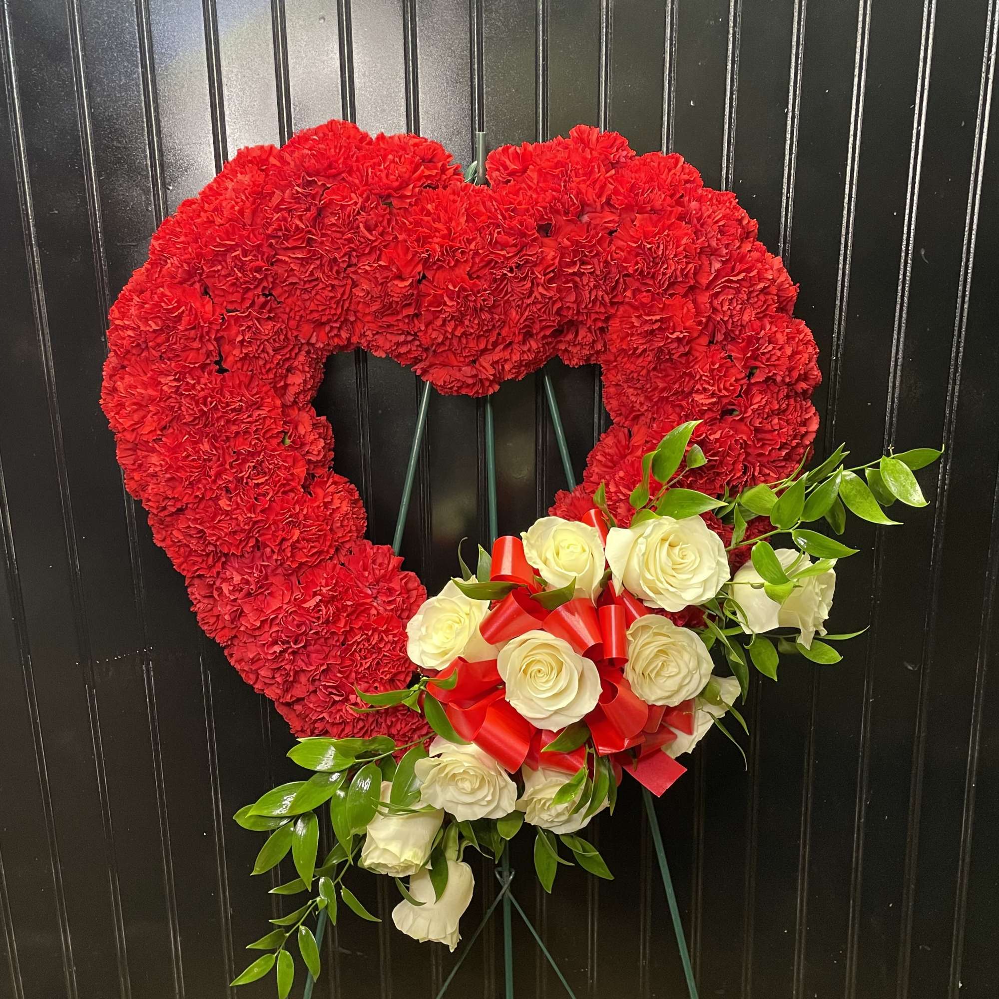 Heart-shaped red carnation wreath with white roses and a red ribbon bow, photo 2 of 2