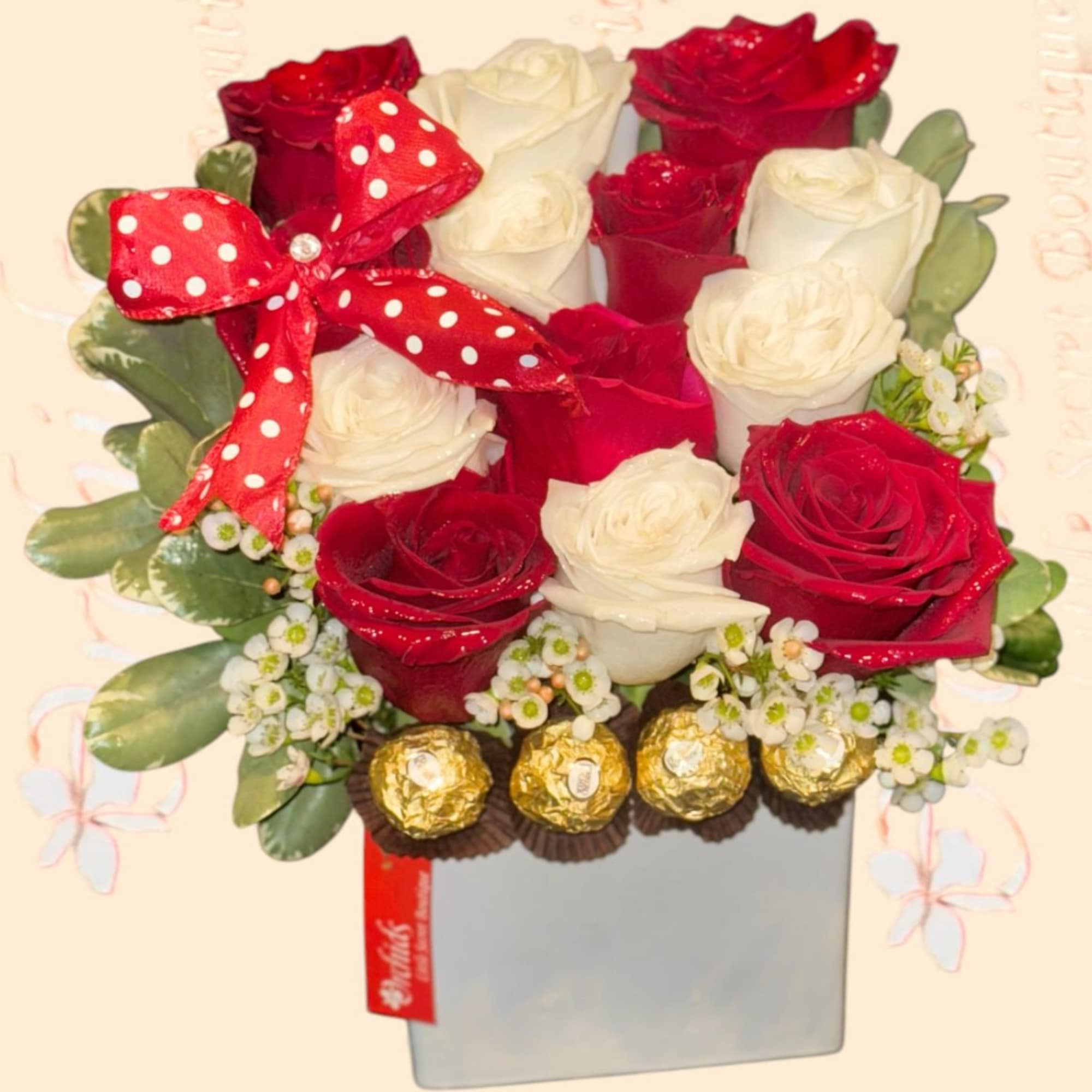 Red and white roses in a square box with a polka-dot bow and chocolates
