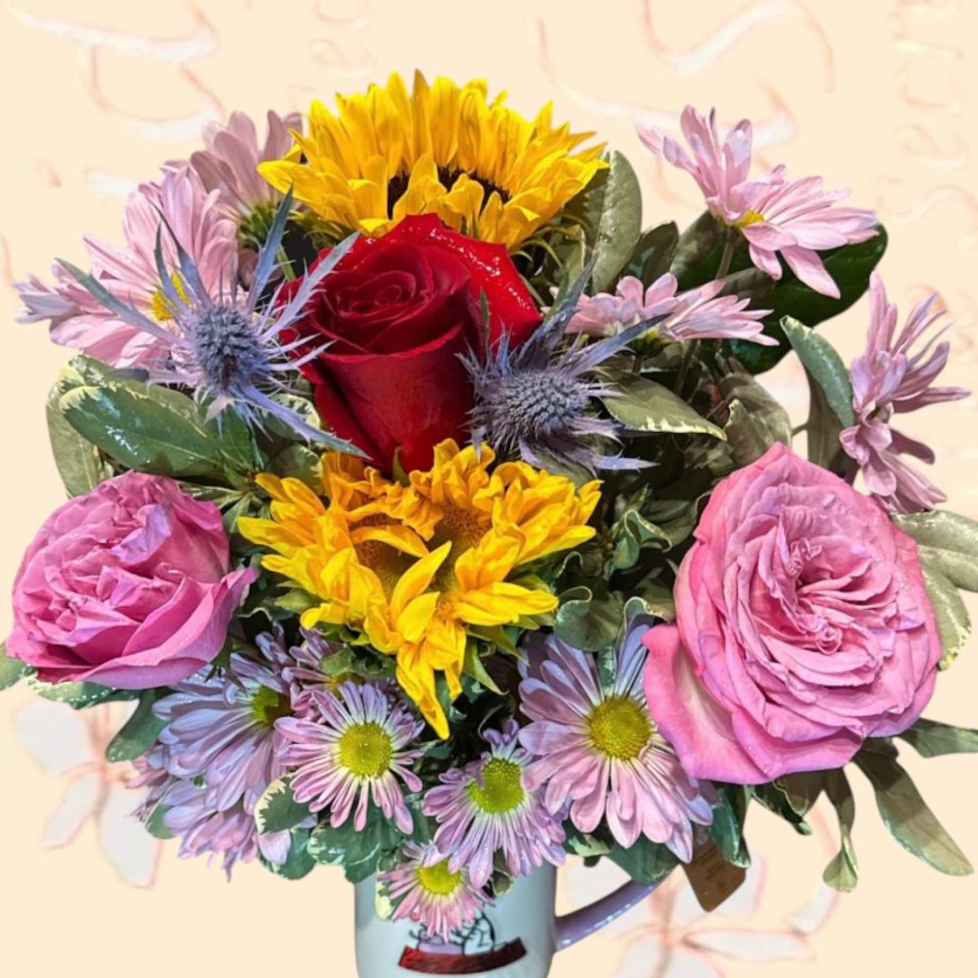 Bouquet of roses, sunflowers, and daisies in a mug vase