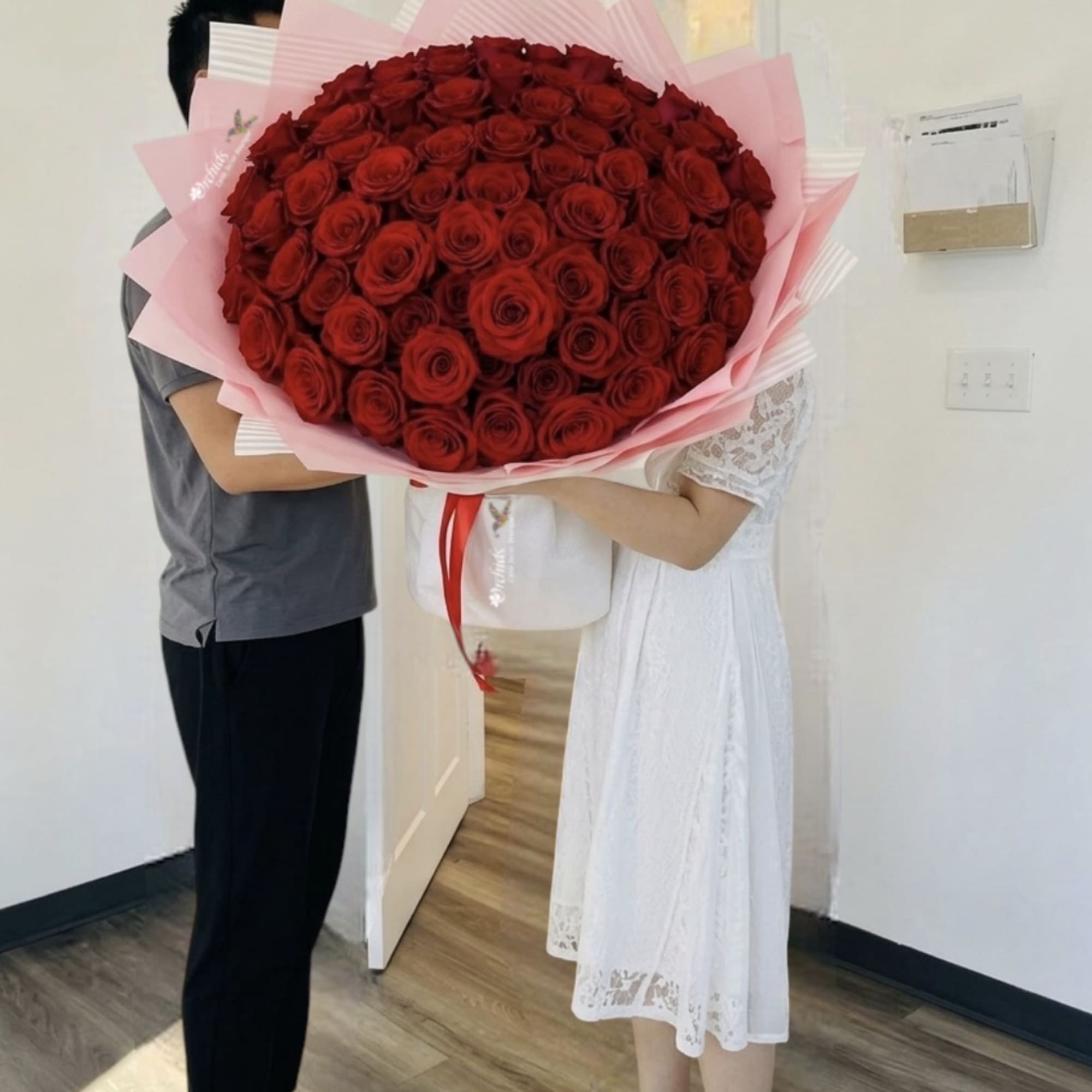 Large bouquet of red roses wrapped in pink paper