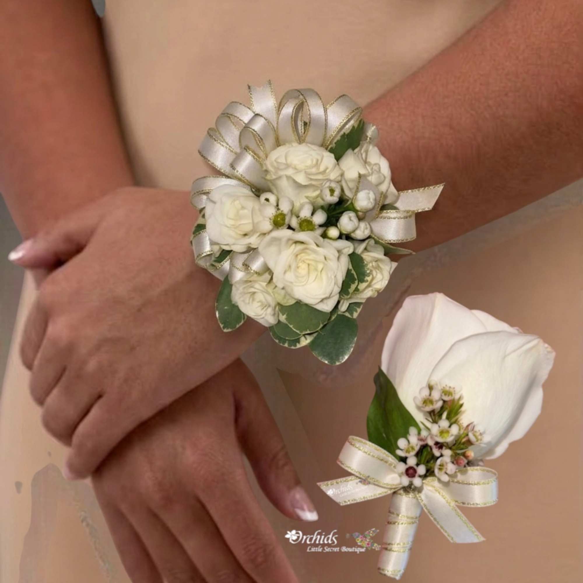 Two white floral wrist corsages worn on arms, each tied with ribbon.