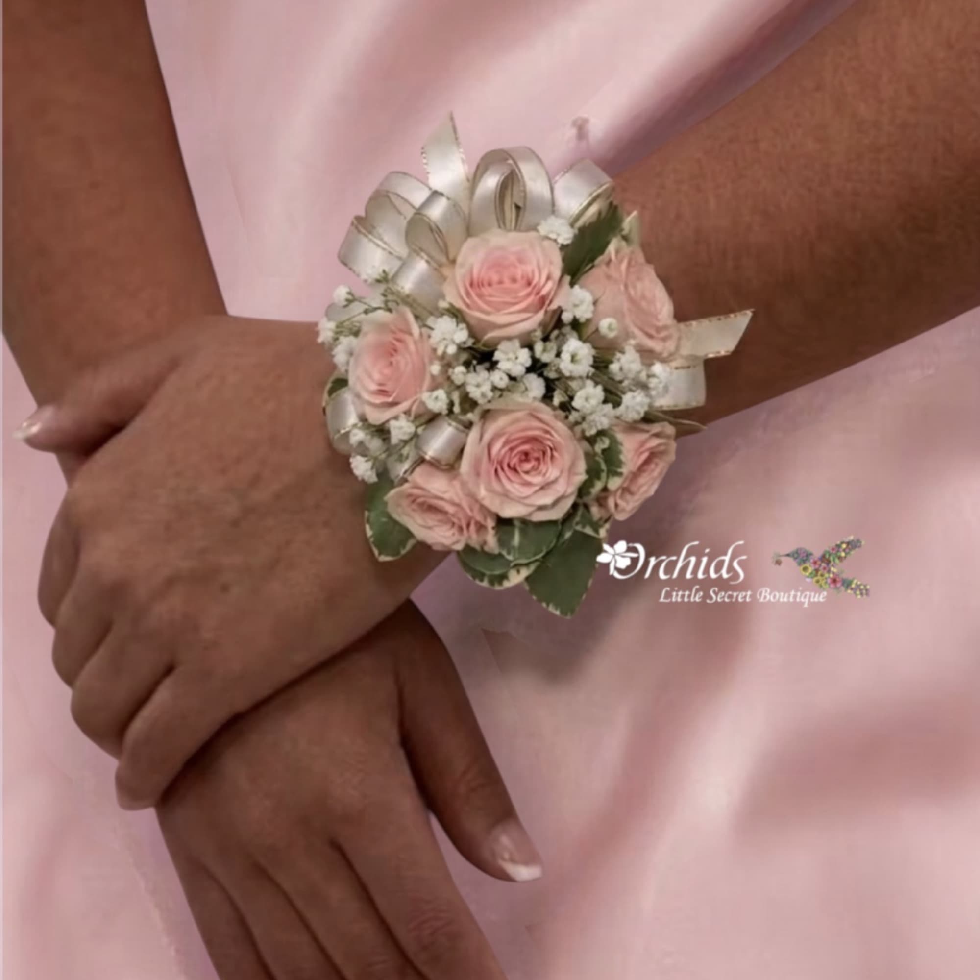 Pink rose wrist corsage with white ribbon and baby's breath