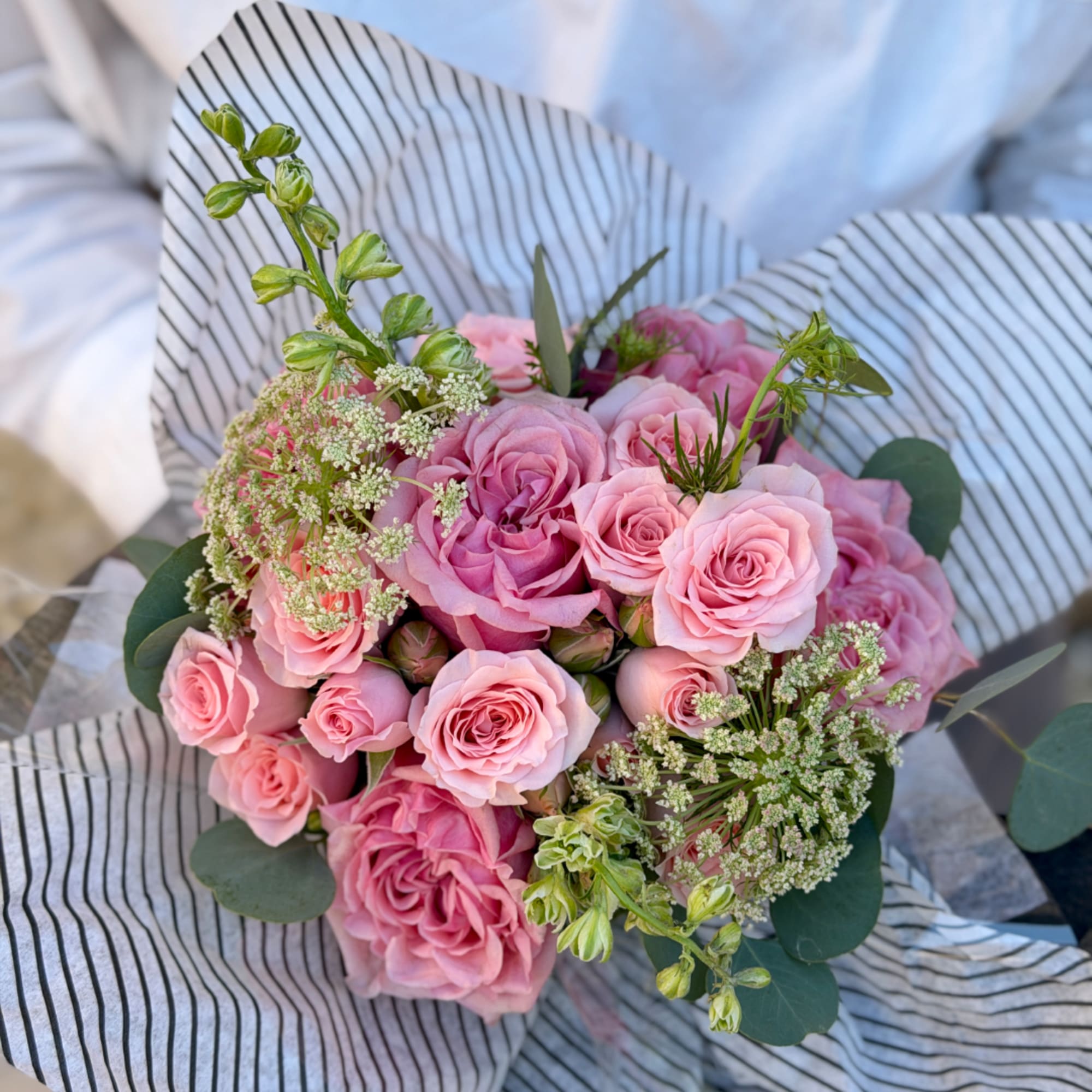 Pink rose bouquet wrapped in striped paper, photo 3 of 3