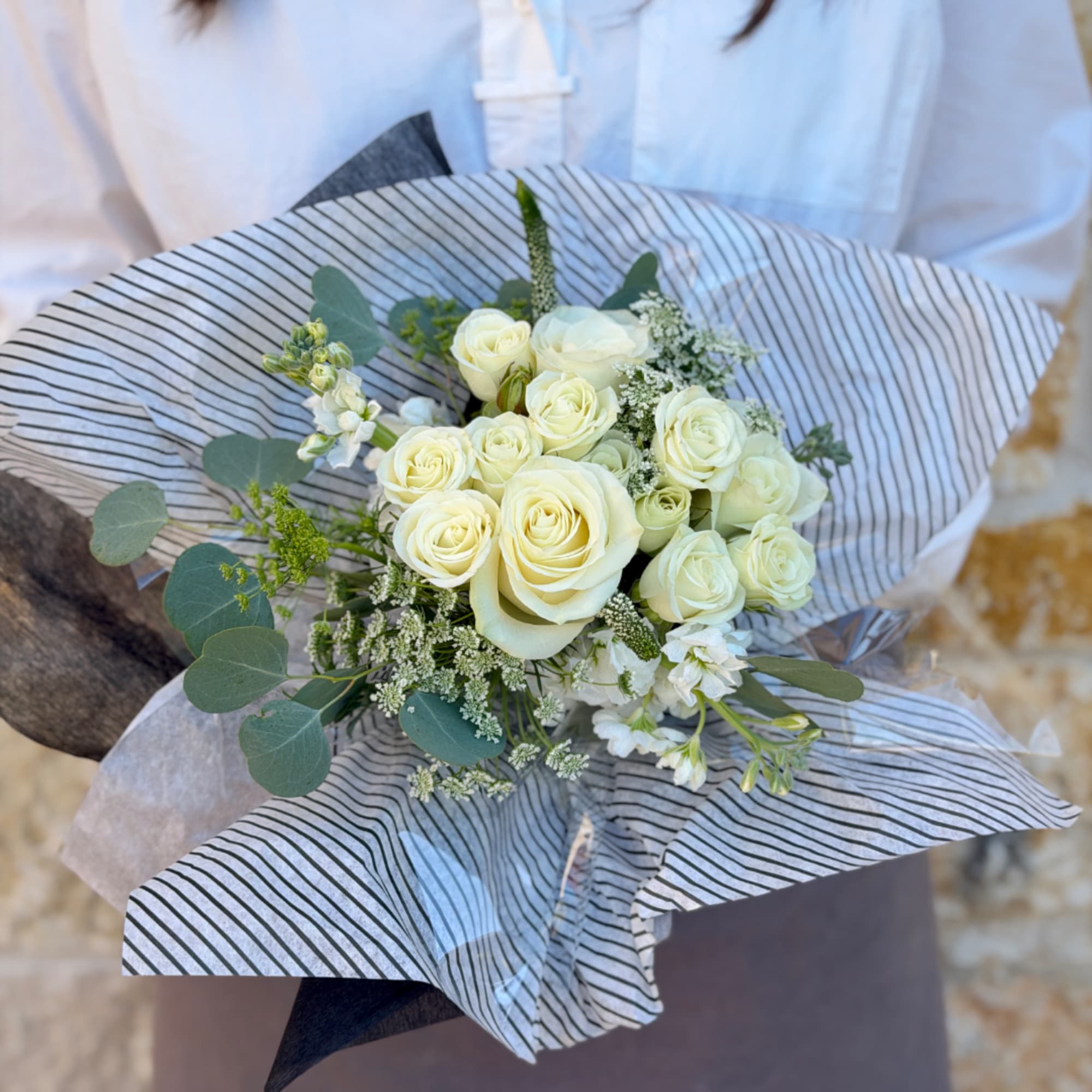 Bouquet of white roses wrapped in striped paper, photo 2 of 3
