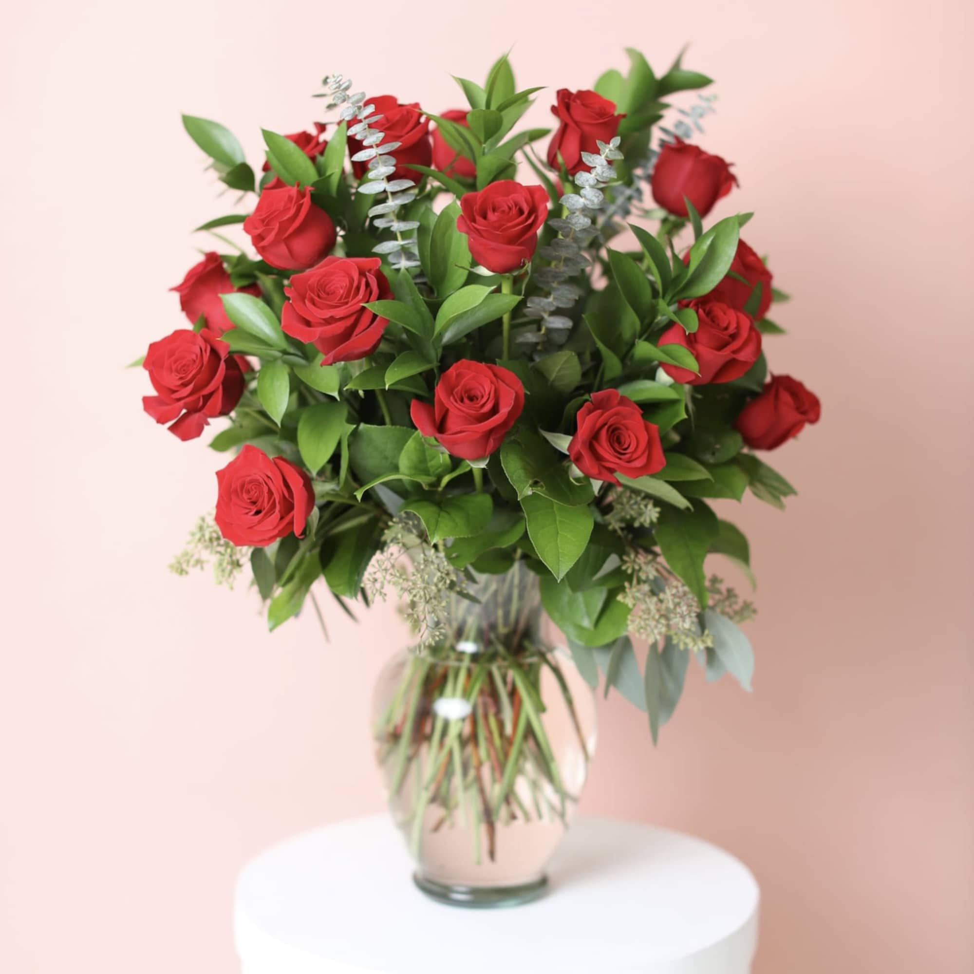 Red roses arranged in a clear glass vase