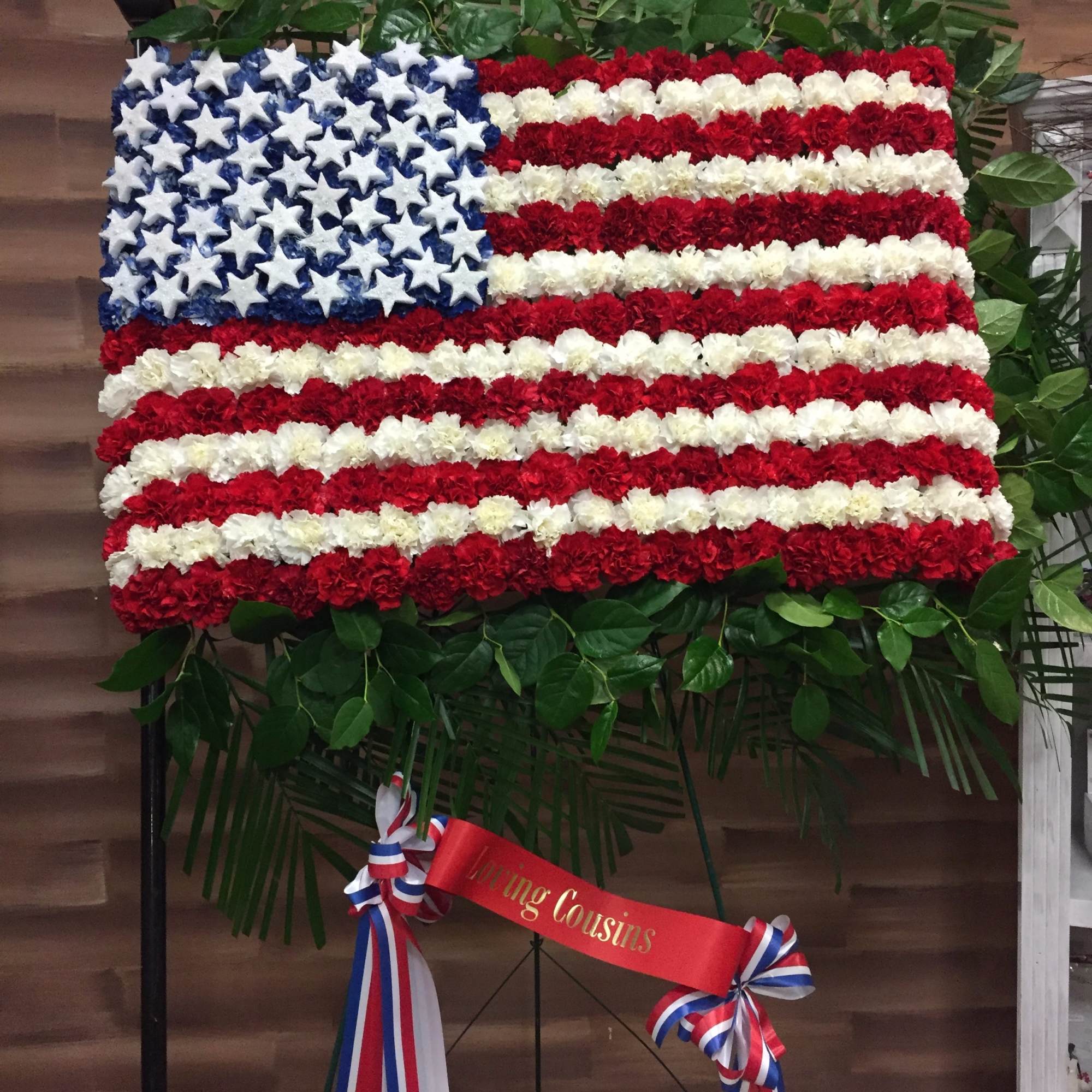 Floral arrangement shaped like the American flag with red, white, and blue flowers