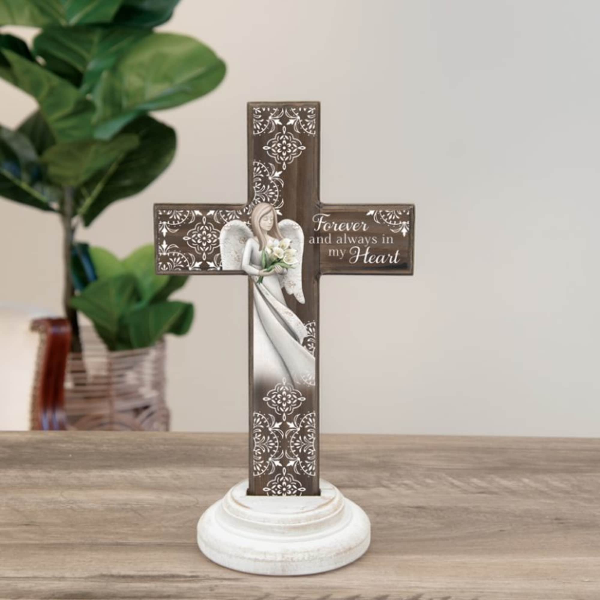 Decorative memorial cross on a white base with an angel and flowers