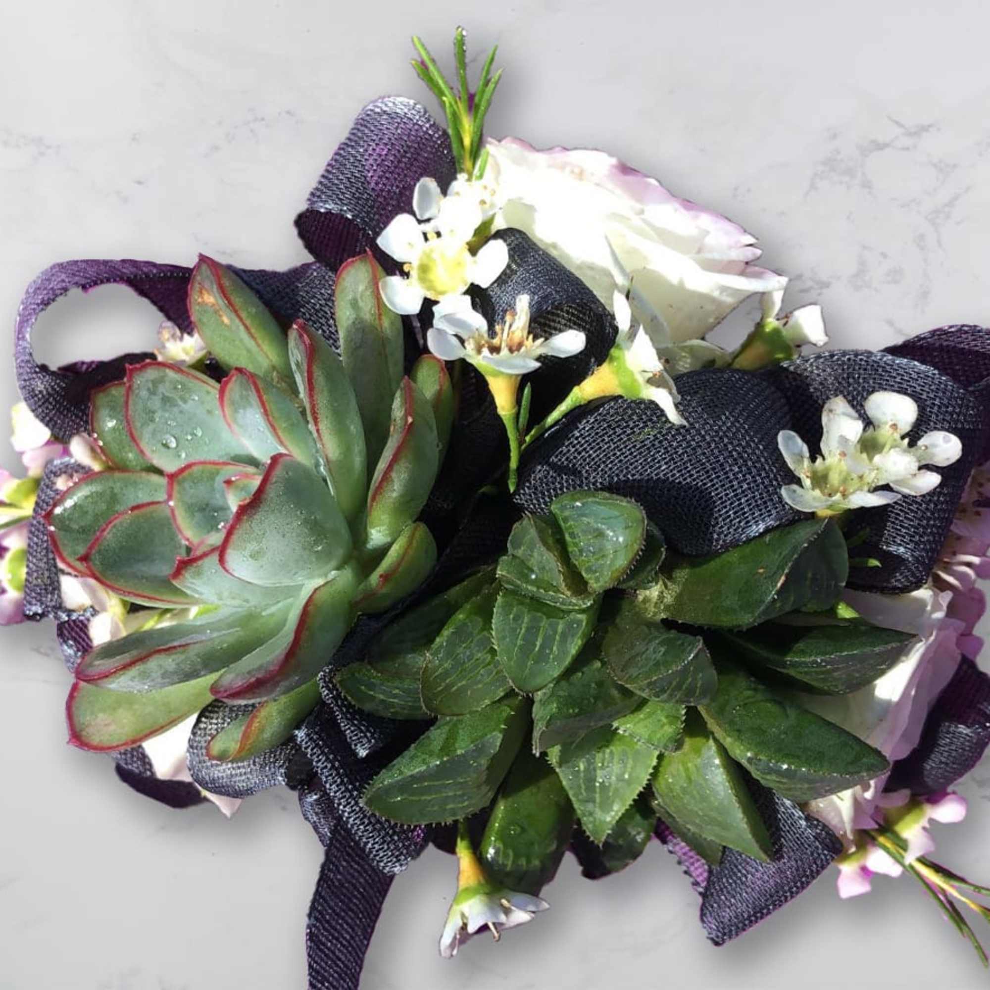 Succulent bouquet with white flowers and dark ribbon