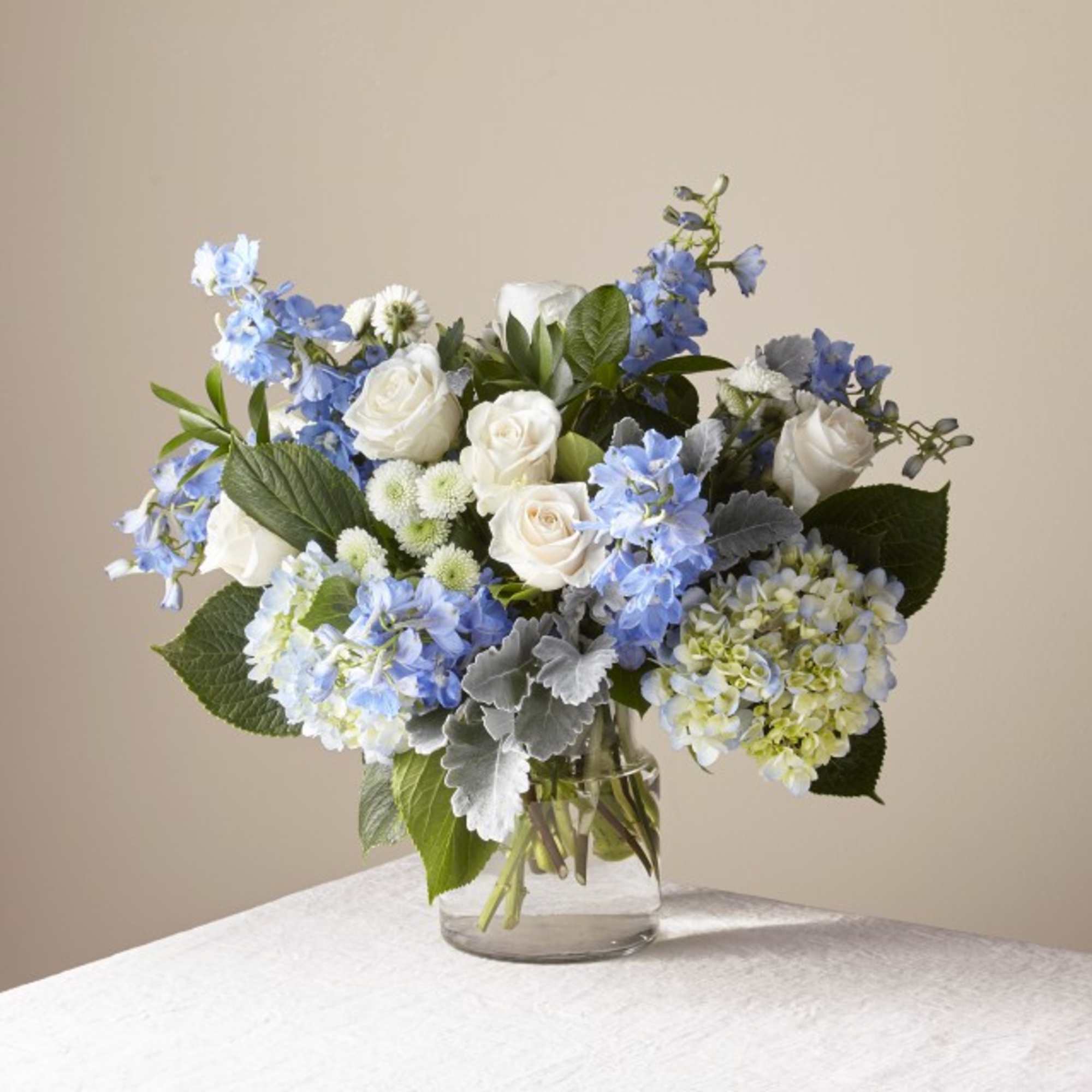 Blue and white flower arrangement in a clear glass vase