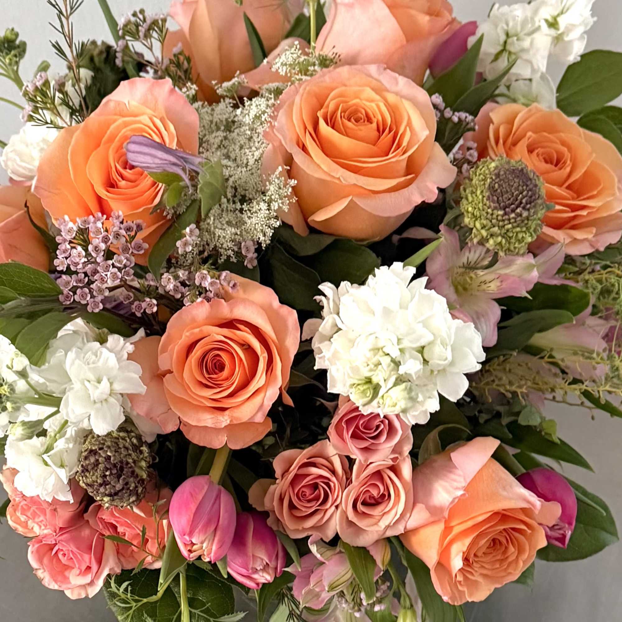 Bouquet of peach and pink roses with white blooms