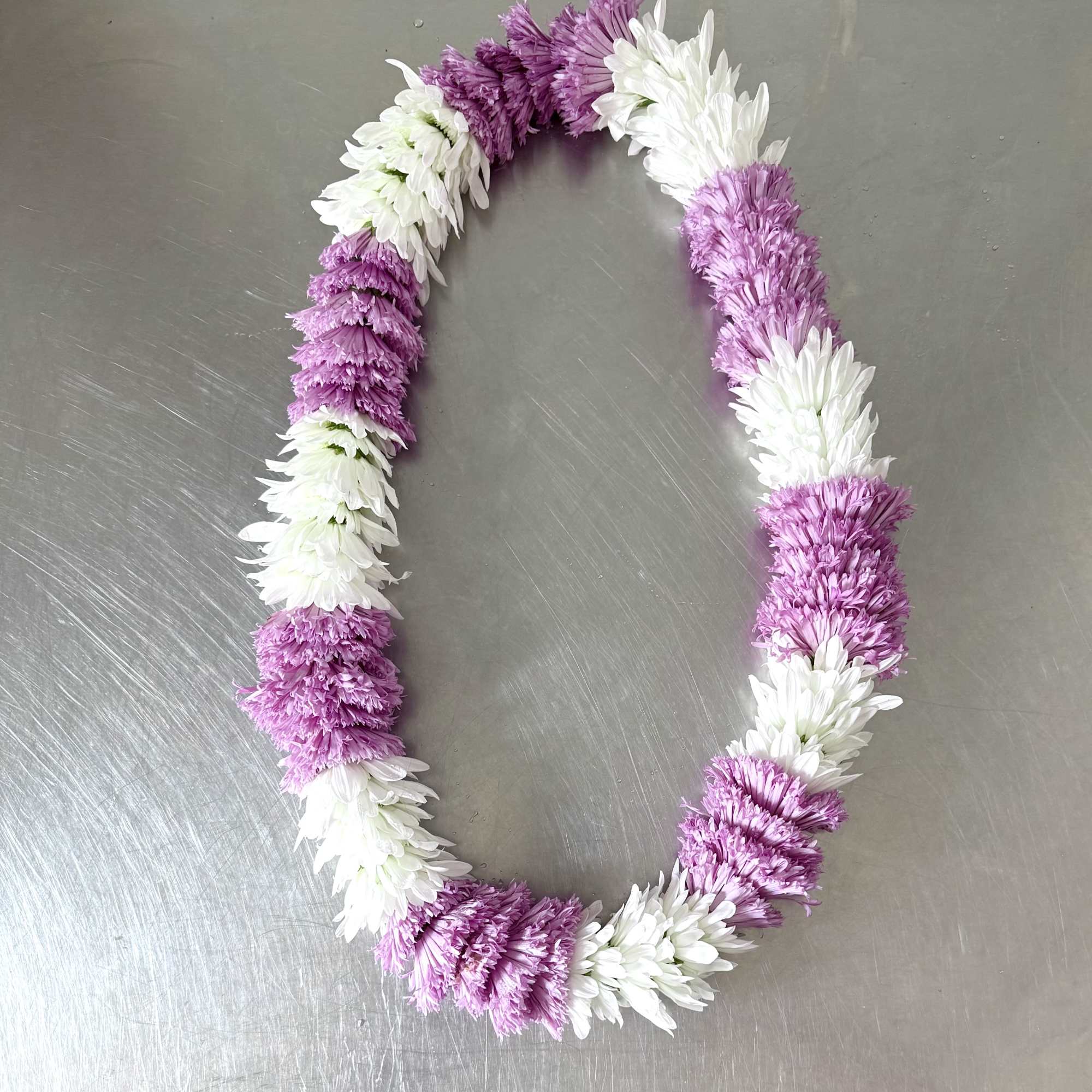 A full, rounded lei handcrafted with alternating sections of fresh white and, photo 4 of 5