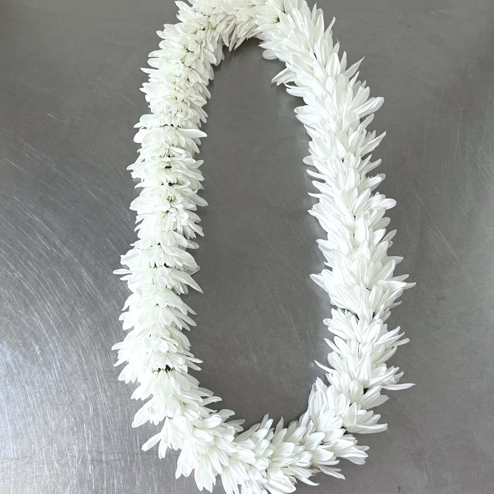 A full, rounded lei handcrafted with alternating sections of fresh white and, photo 2 of 3
