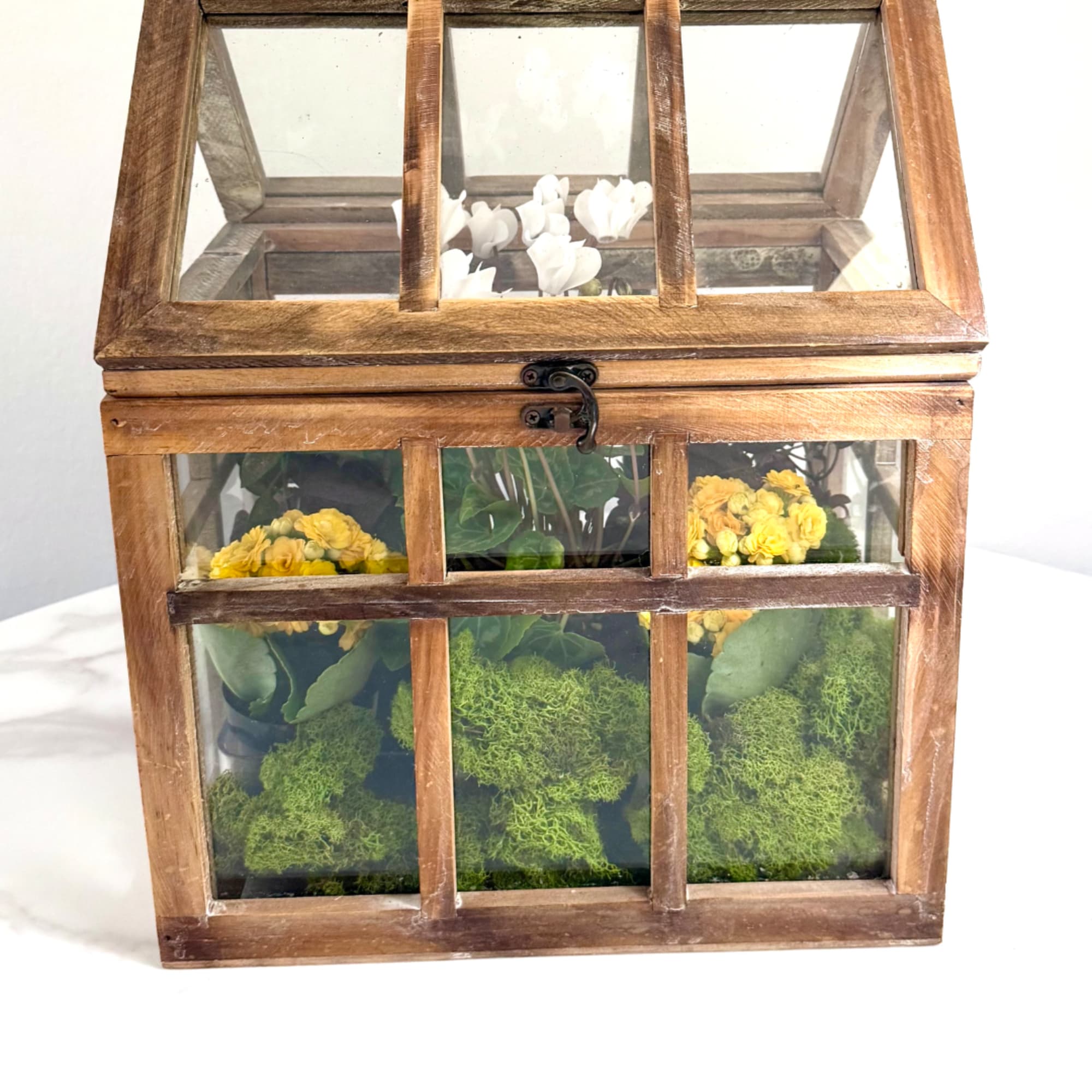 Wooden glass terrarium with yellow and white flowers inside