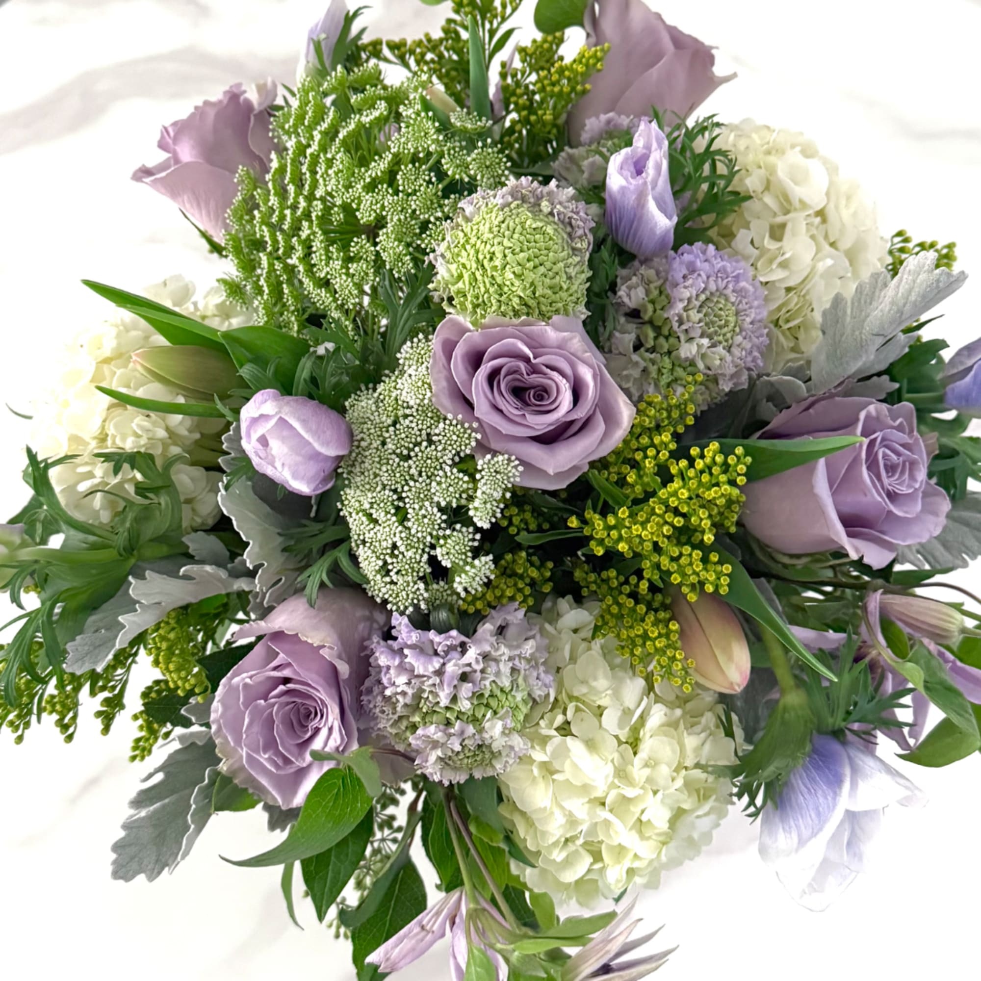 Lavender roses and white hydrangeas in a round bouquet