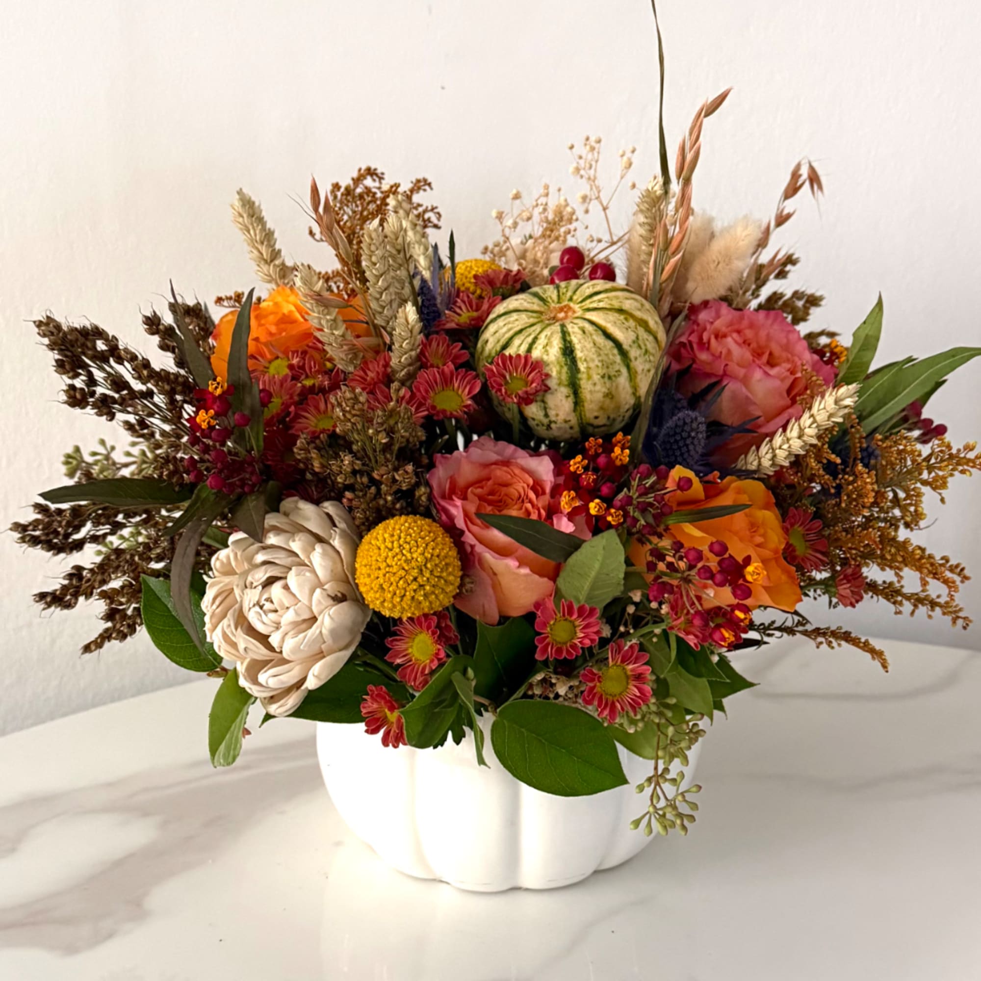 Mixed autumn bouquet in a white pumpkin-shaped vase