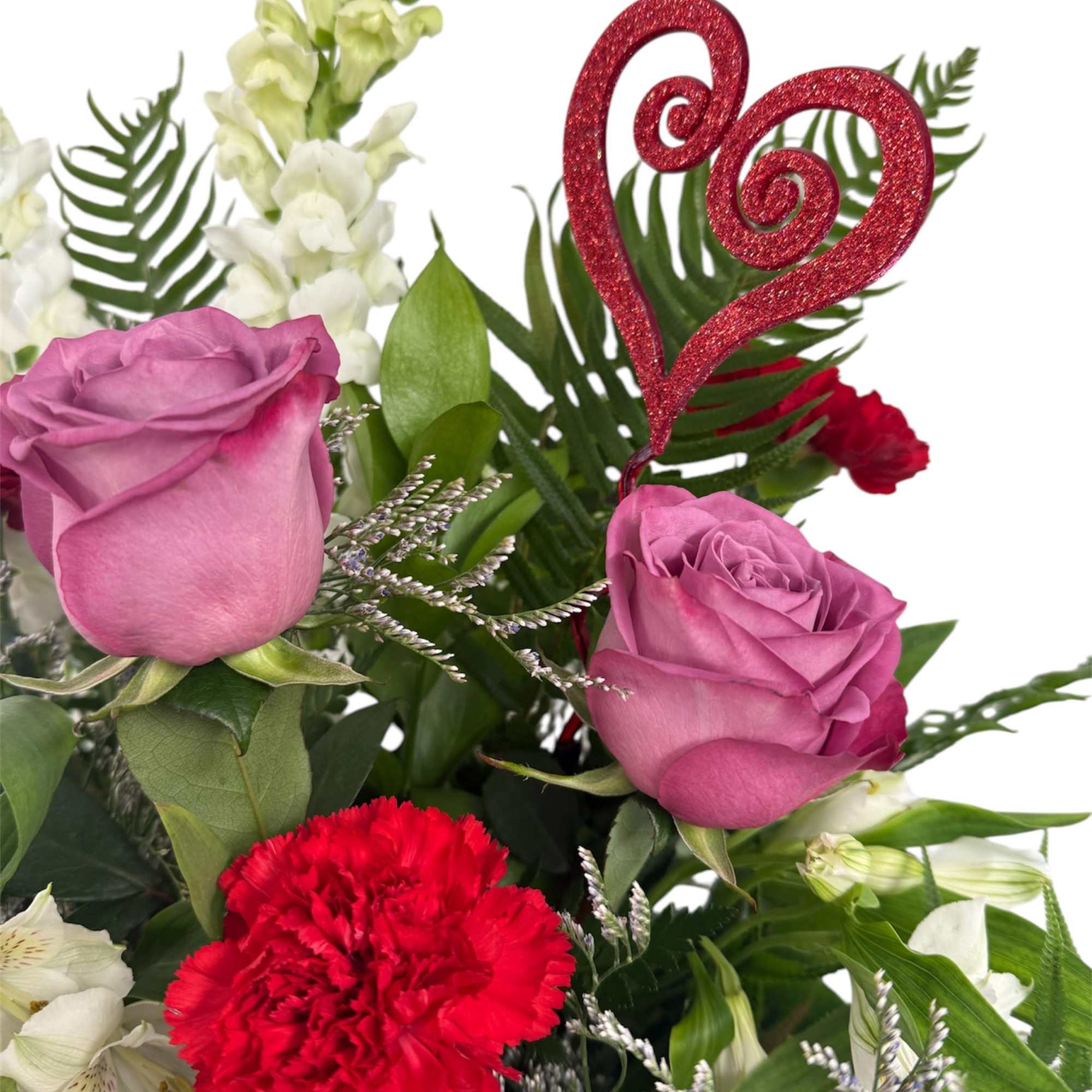 Bouquet of pink roses, red carnations, and white snapdragons with a glitter heart pick