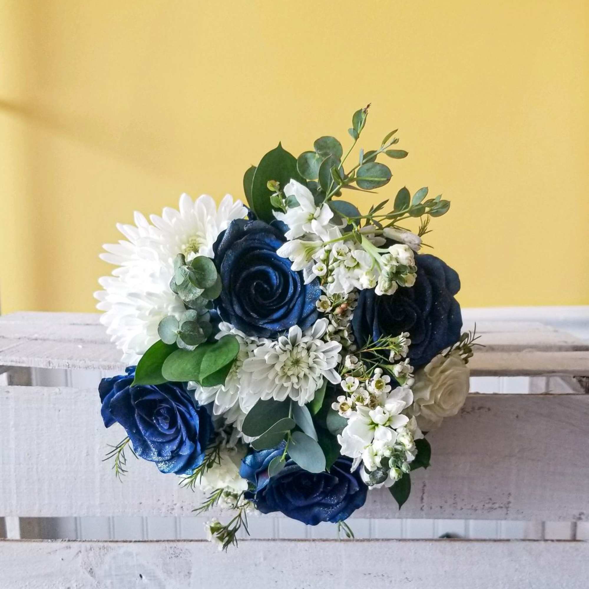 Handheld white and dark blue prom bouquet with mixed flowers.
Actual Bouquets will