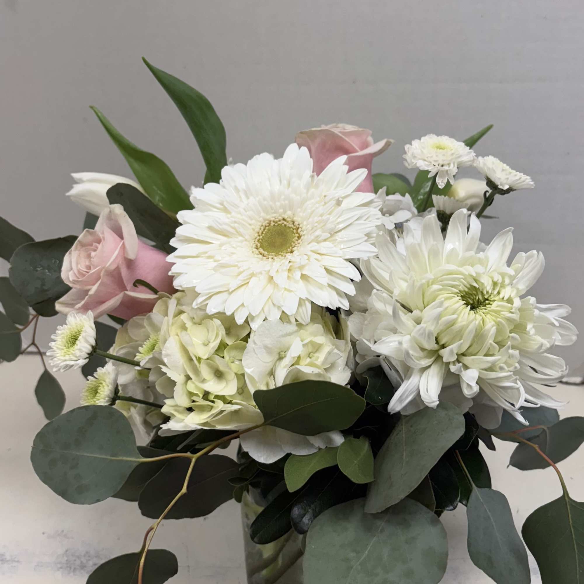 Pink roses and white daisies in a glass vase