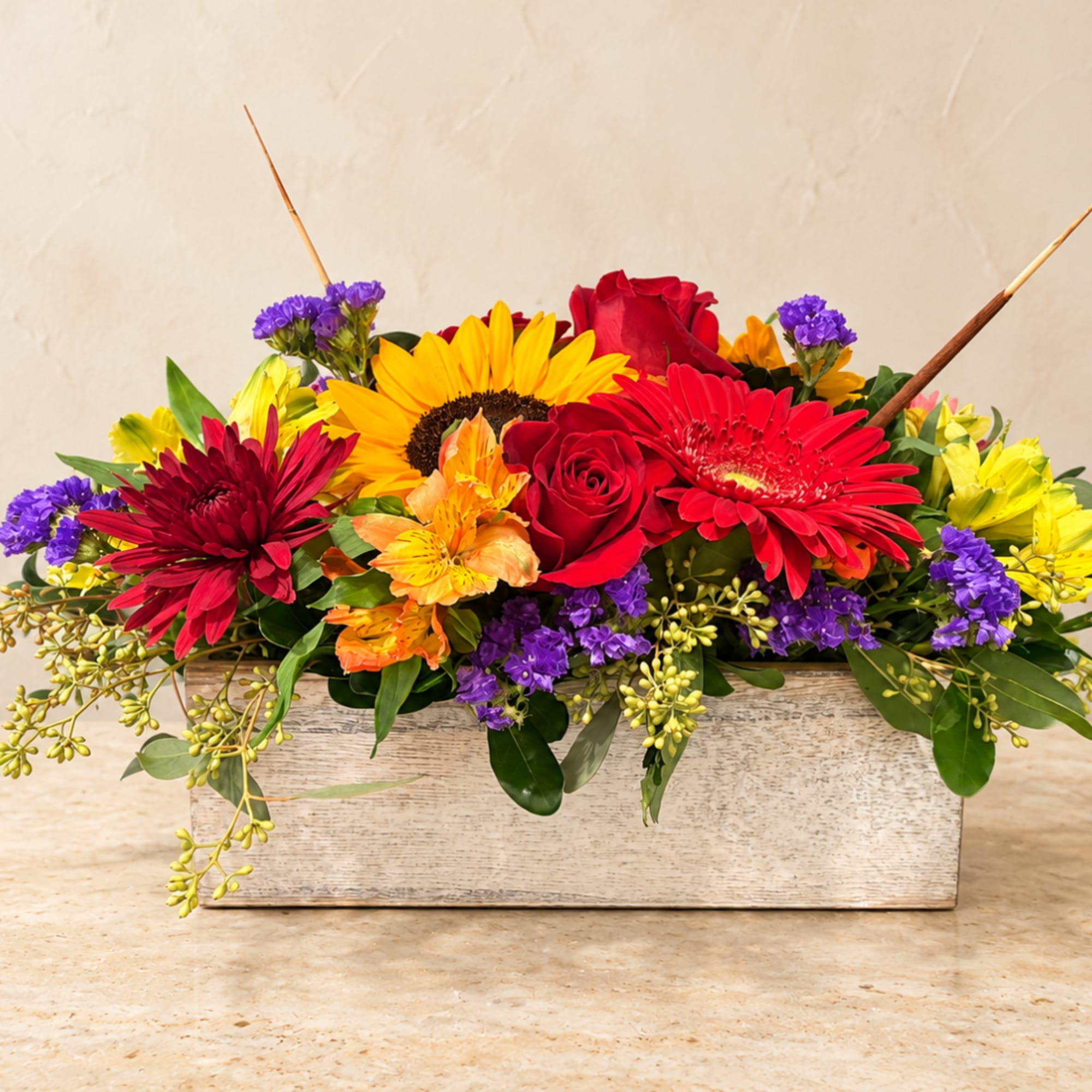 Bright mixed flower arrangement in a rustic wooden box