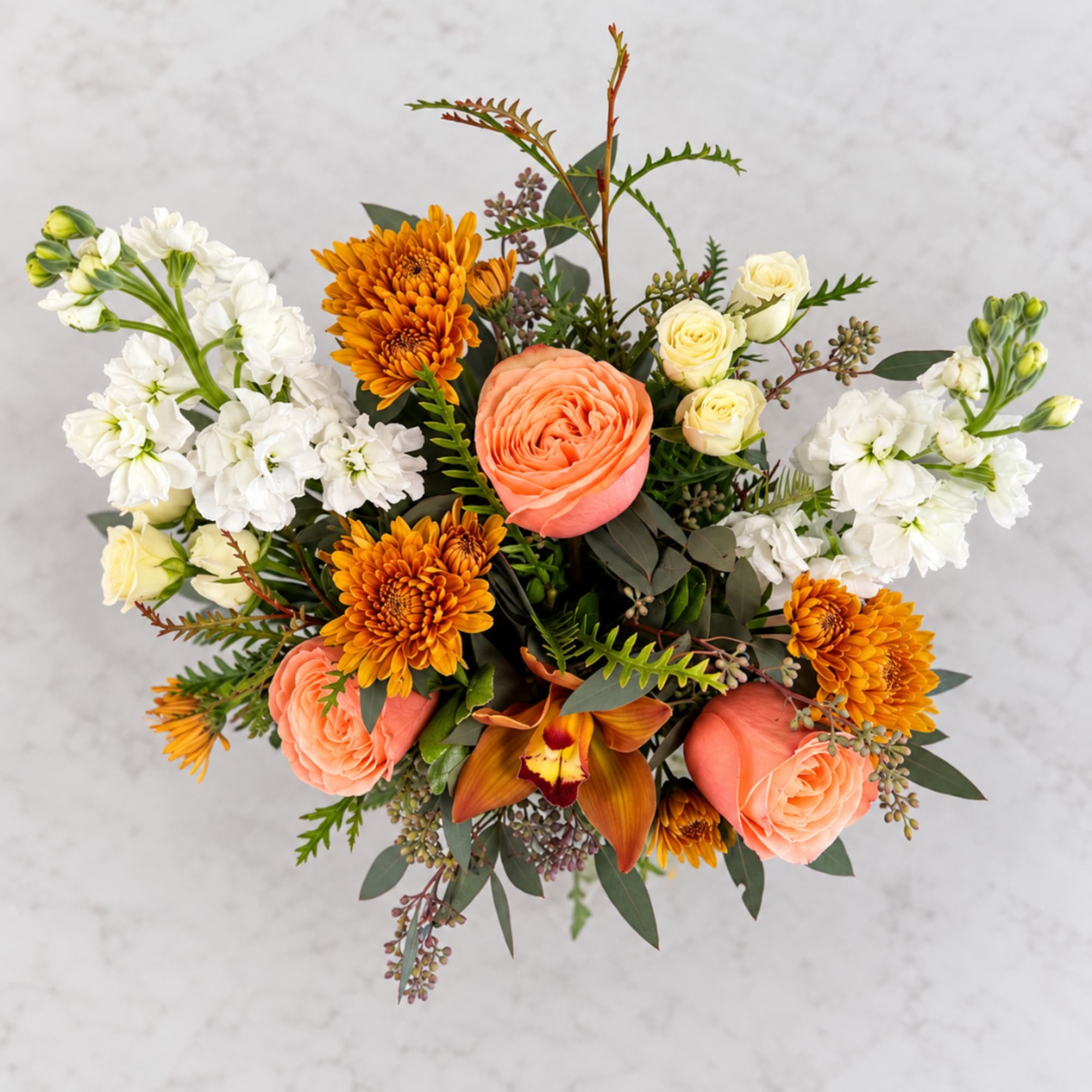 Bouquet of peach roses, orange chrysanthemums, and white stock flowers