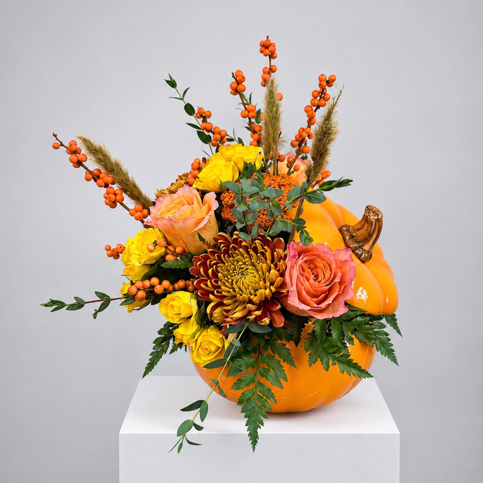Pumpkin-shaped arrangement with roses, mums, and orange berries