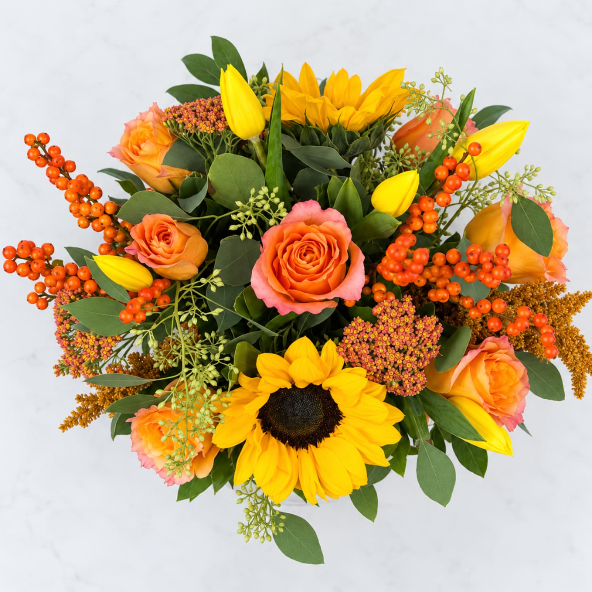 Bouquet of orange roses and yellow sunflowers with orange berries