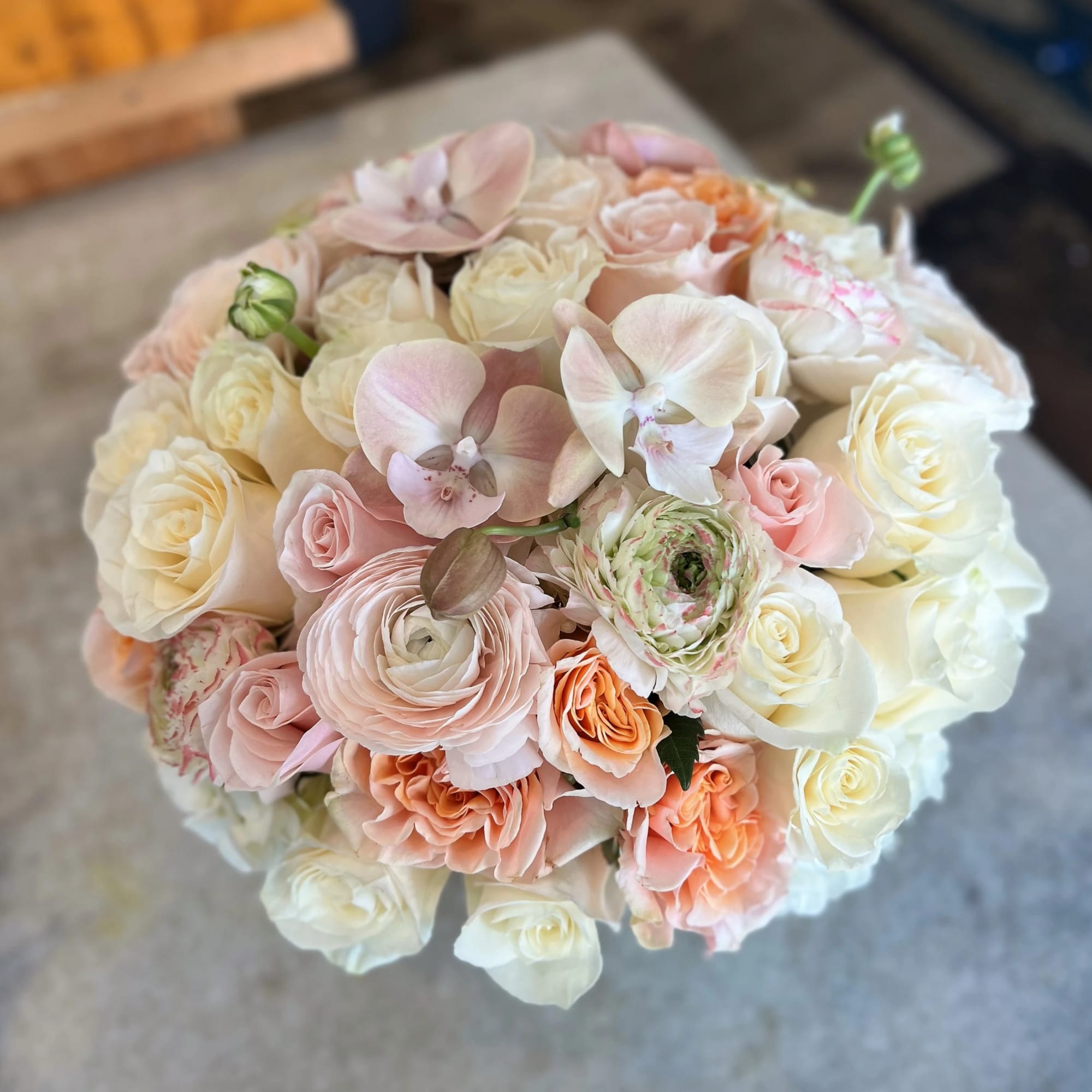 Round bouquet of blush, peach, and white flowers