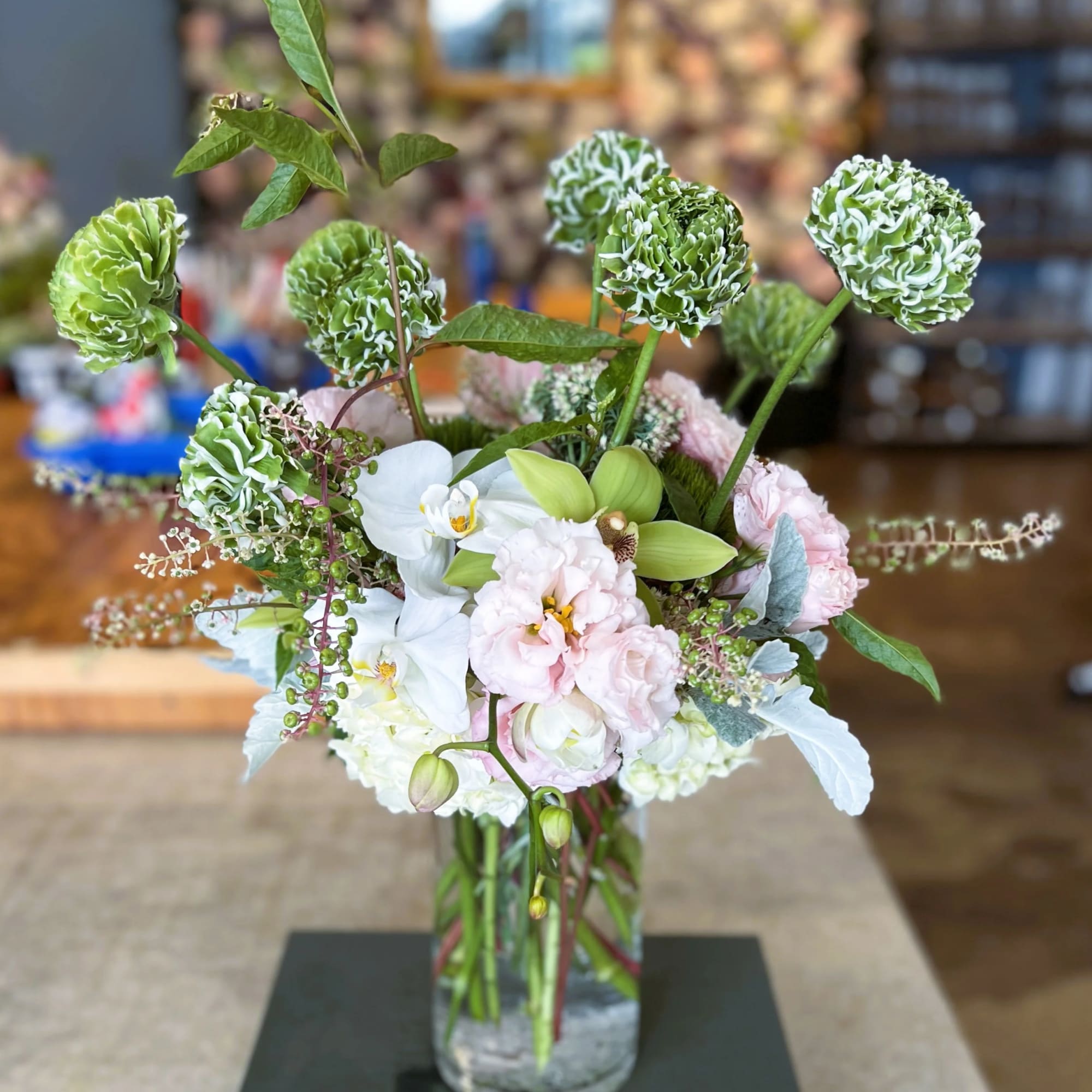 Mixed floral arrangement in a clear glass vase with white and pale pink blooms