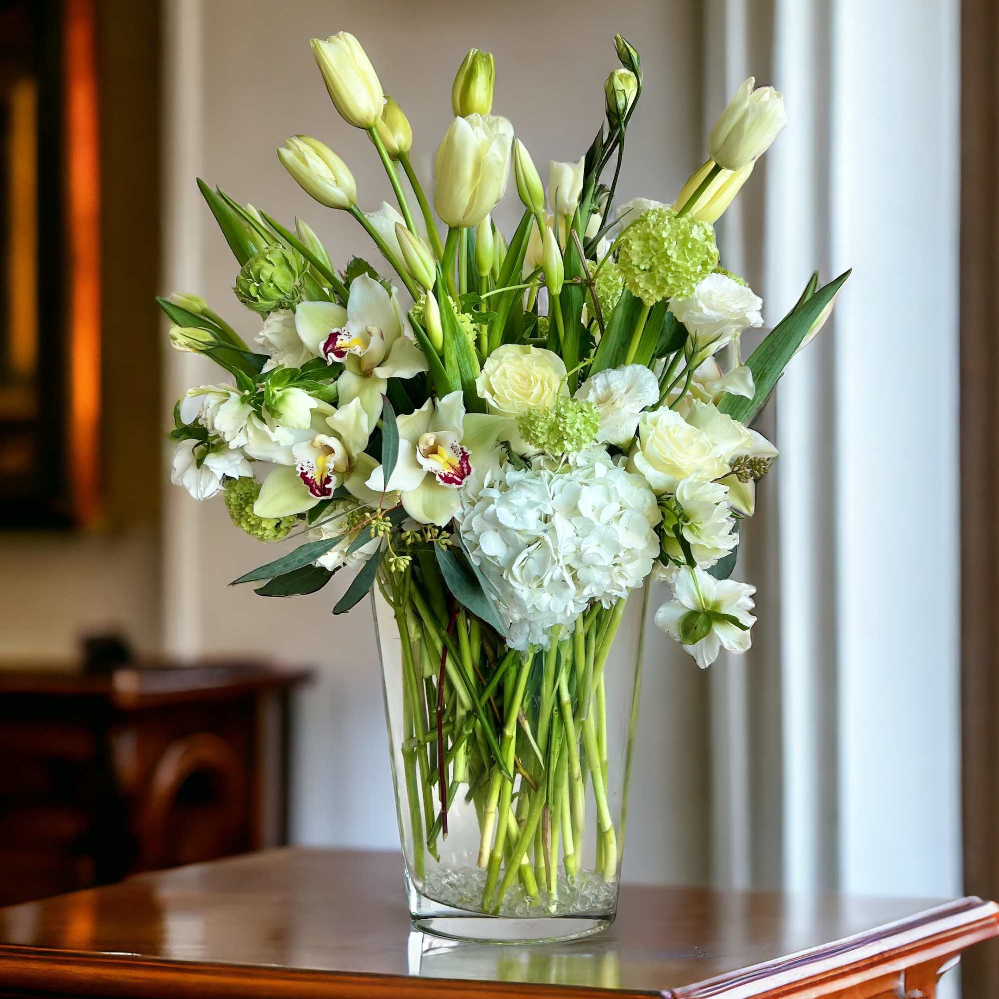 White and pale green floral arrangement in a clear glass vase, photo 2 of 2