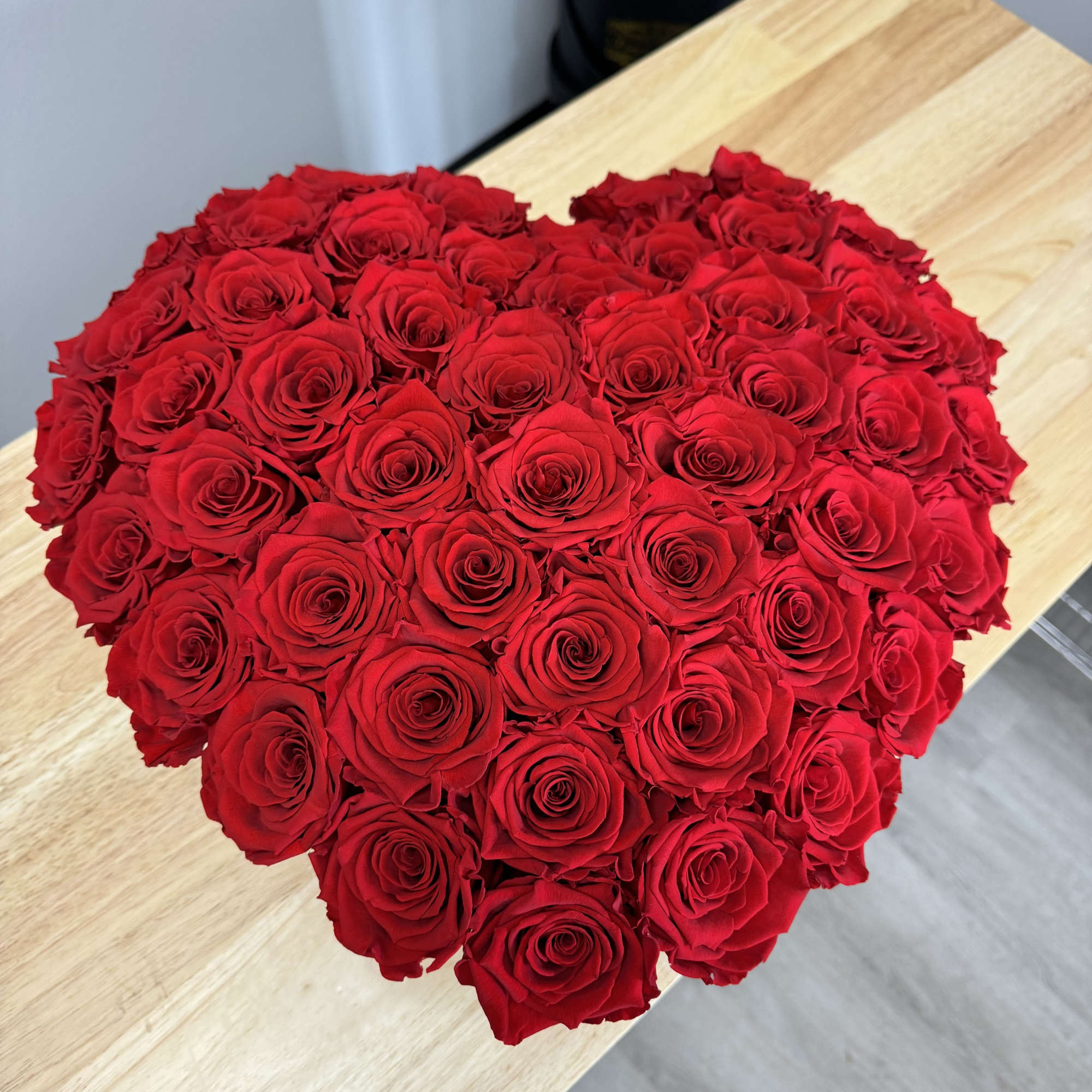 Heart-shaped bouquet of red roses on a table