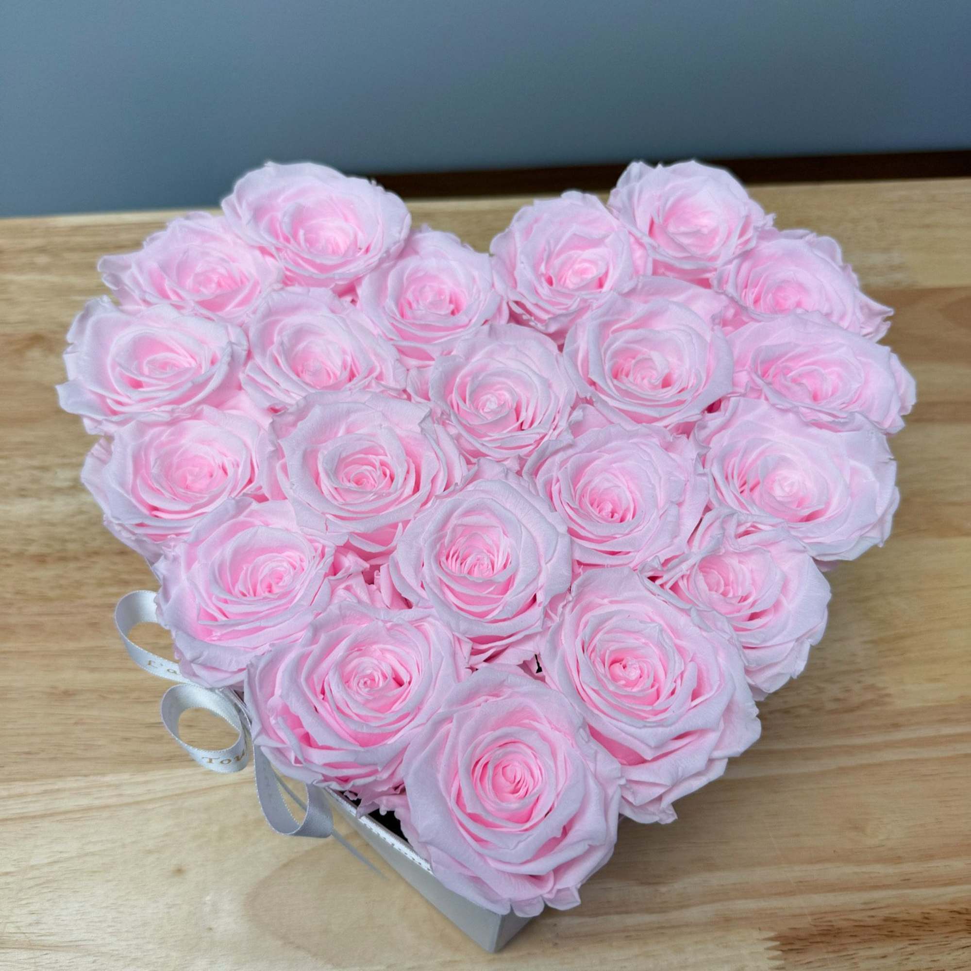 Heart-shaped box filled with pale pink roses
